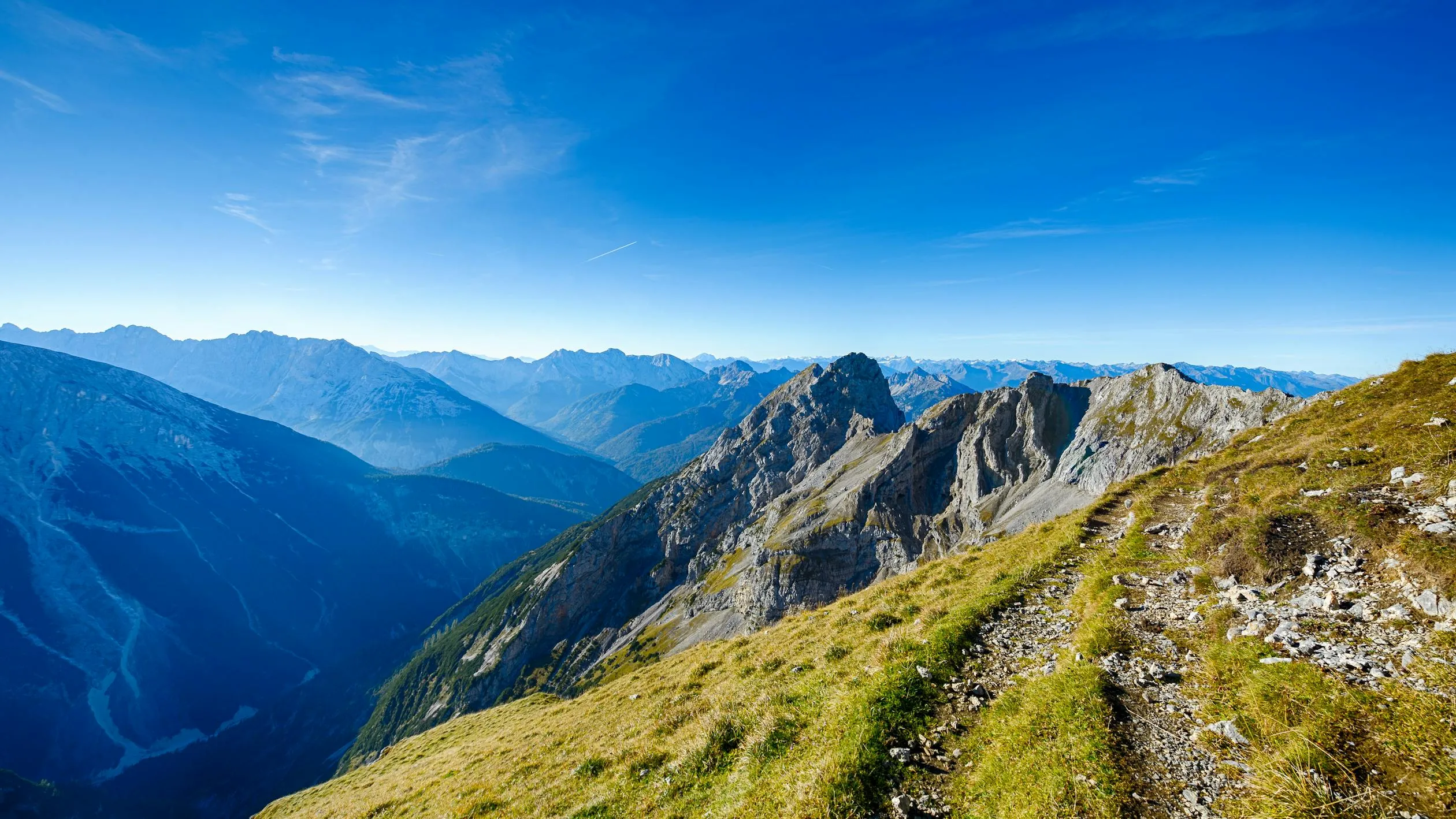 Mountain Range Under Bright Blue Sky and Scattered Clouds