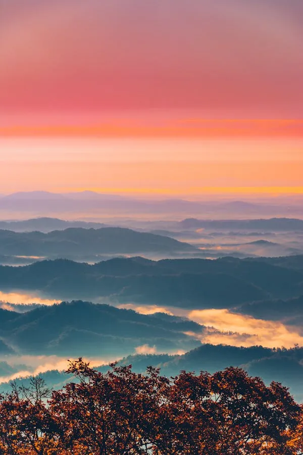 Mountain Range Under Colorful Sunrise with Light Clouds