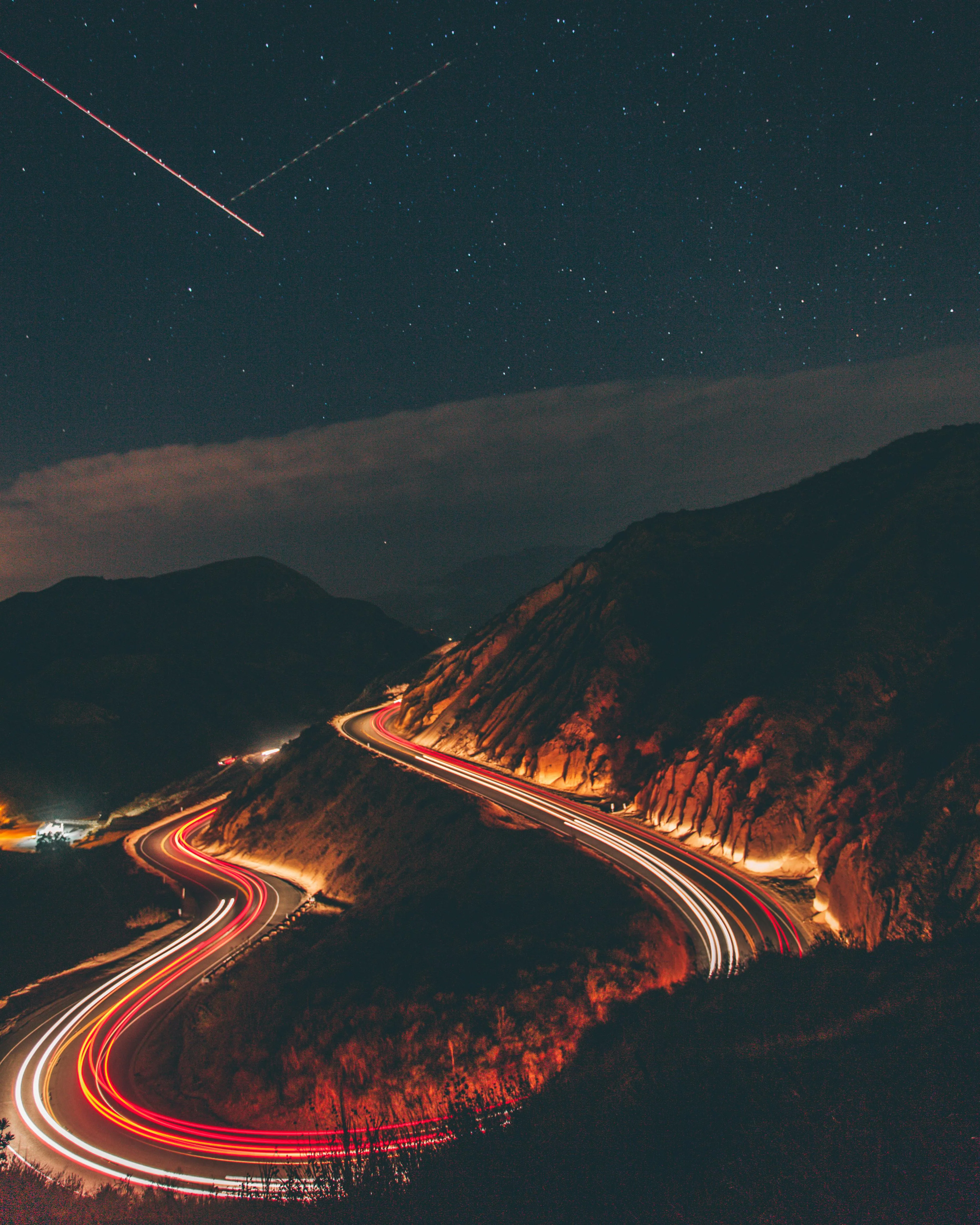 Night Highway with Bright Car Lights and Starry Sky