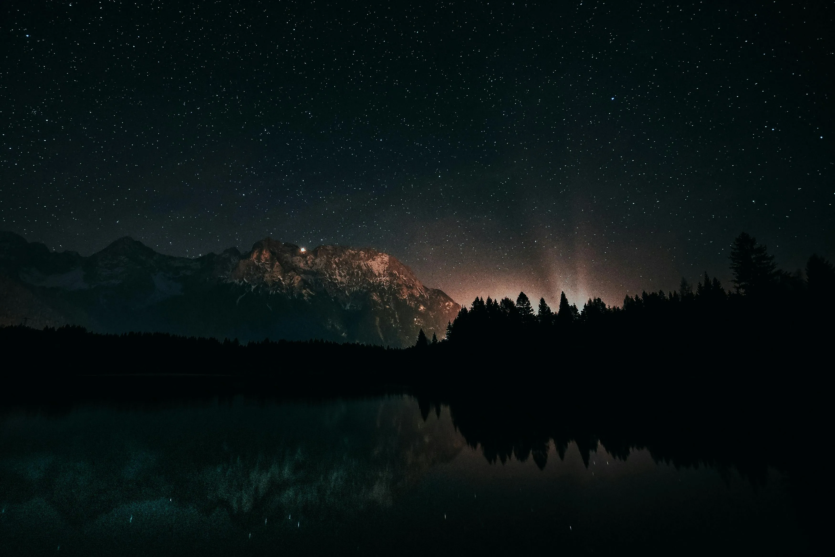 Night Sky Reflected on Lake Beneath Distant Clouds Image