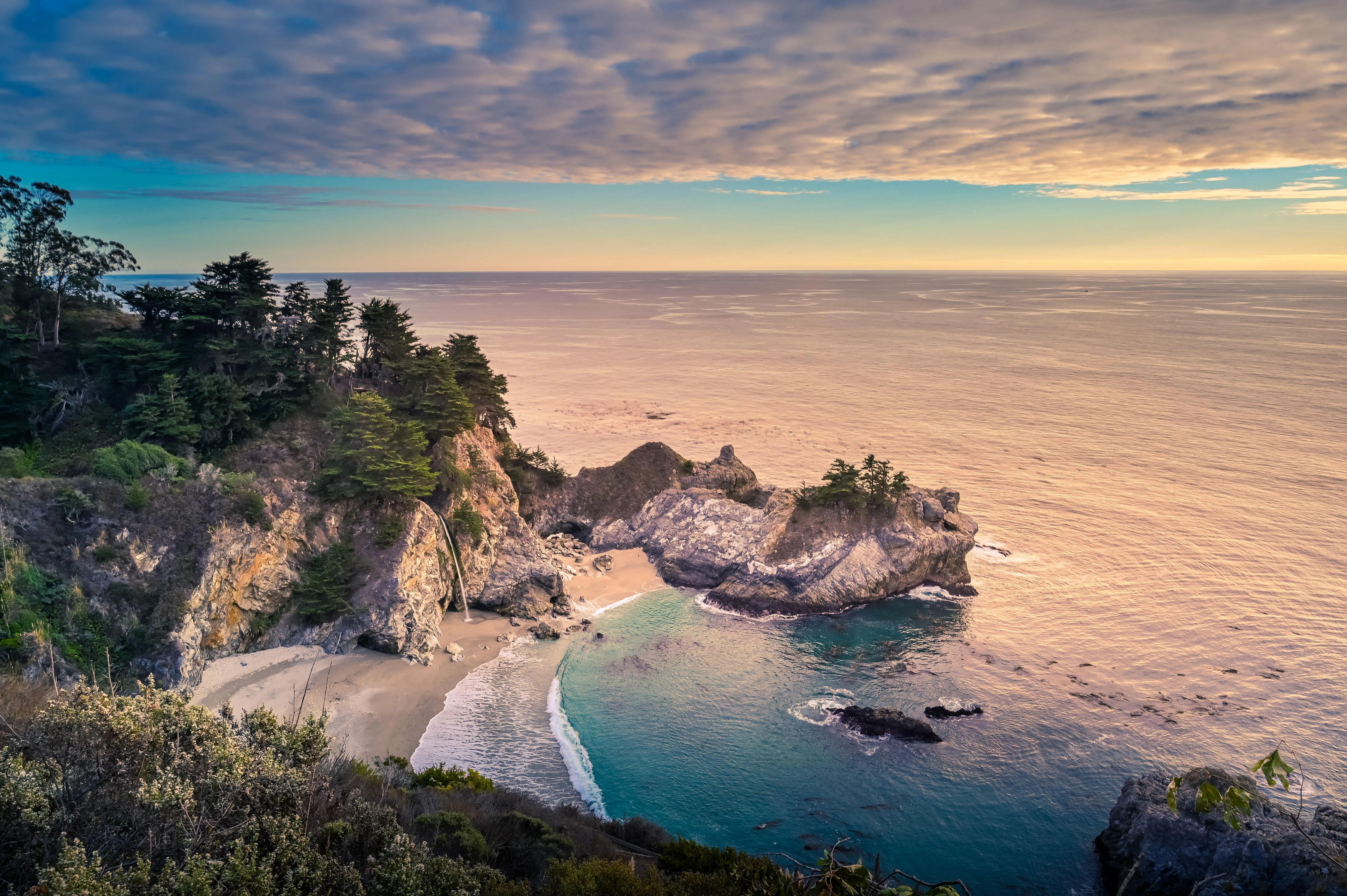 Ocean View from a Cliff with Lush Green Trees and Sky