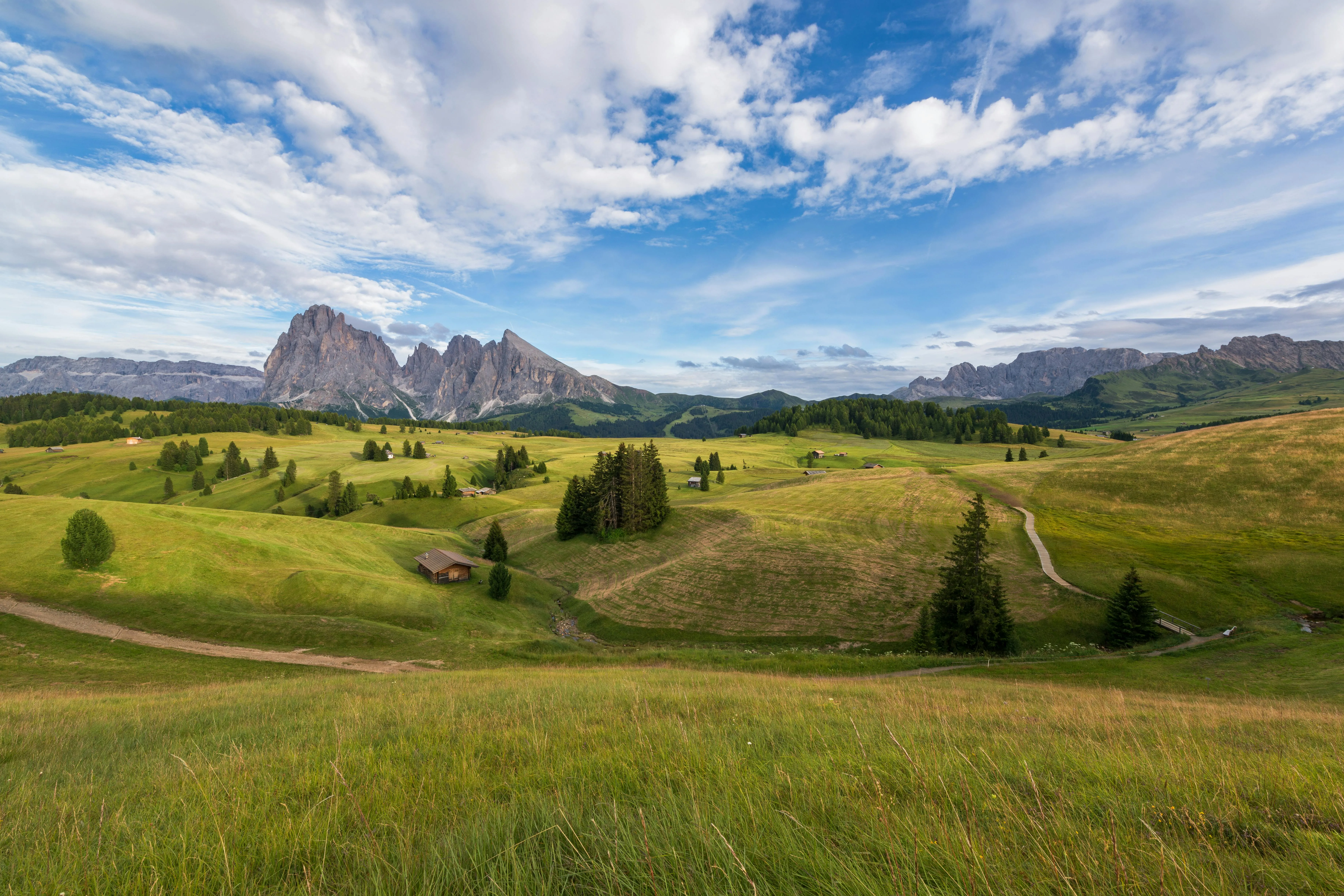 Open Green Valley with Clouds Above Mountain Range Image