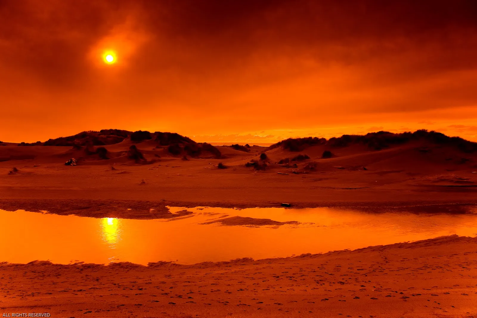 Orange Sunset Casting Warm Glow on Desert Sand Free Image
