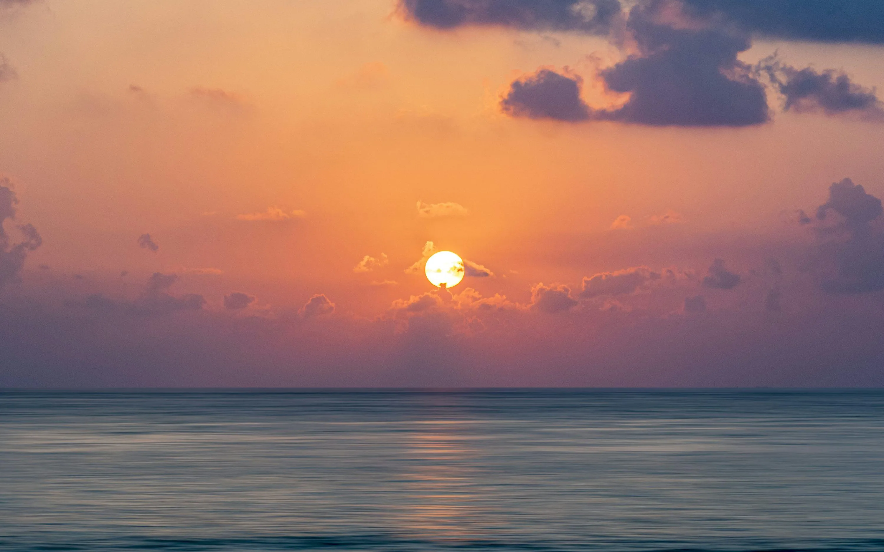 Orange Sunset over Ocean Horizon with Calm Reflections