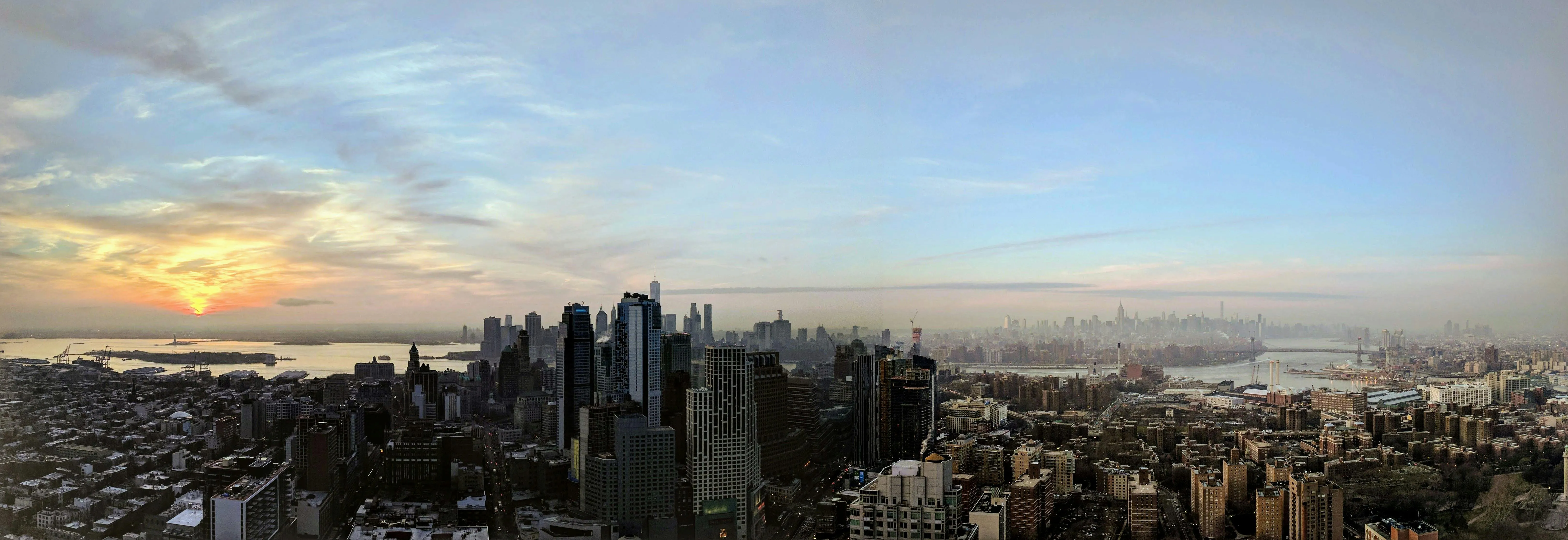 Panoramic Cityscape Beneath Soft Blue Cloudy Sky Image