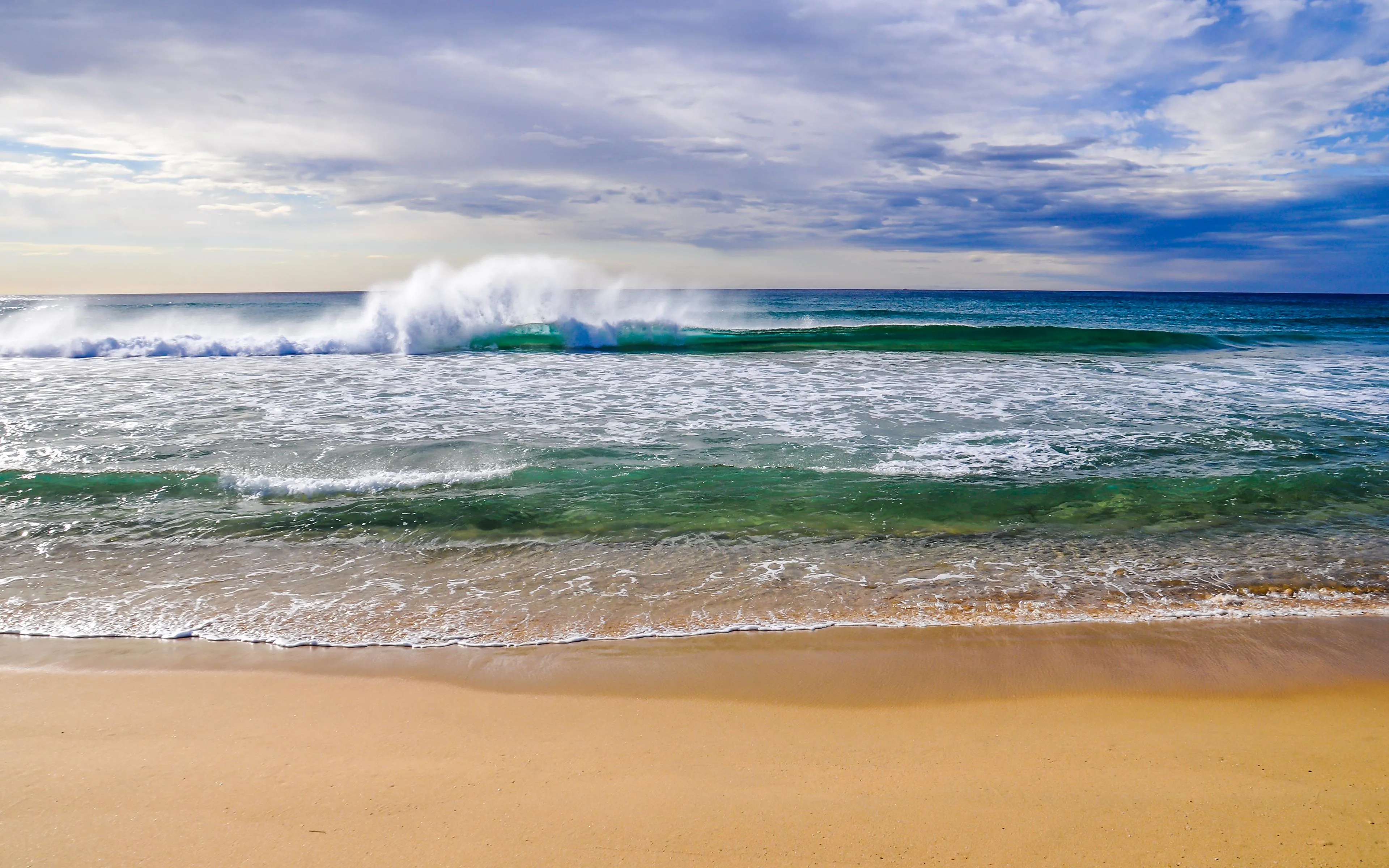 Peaceful Beach With Calm Waves And Blue Sky Wallpaper