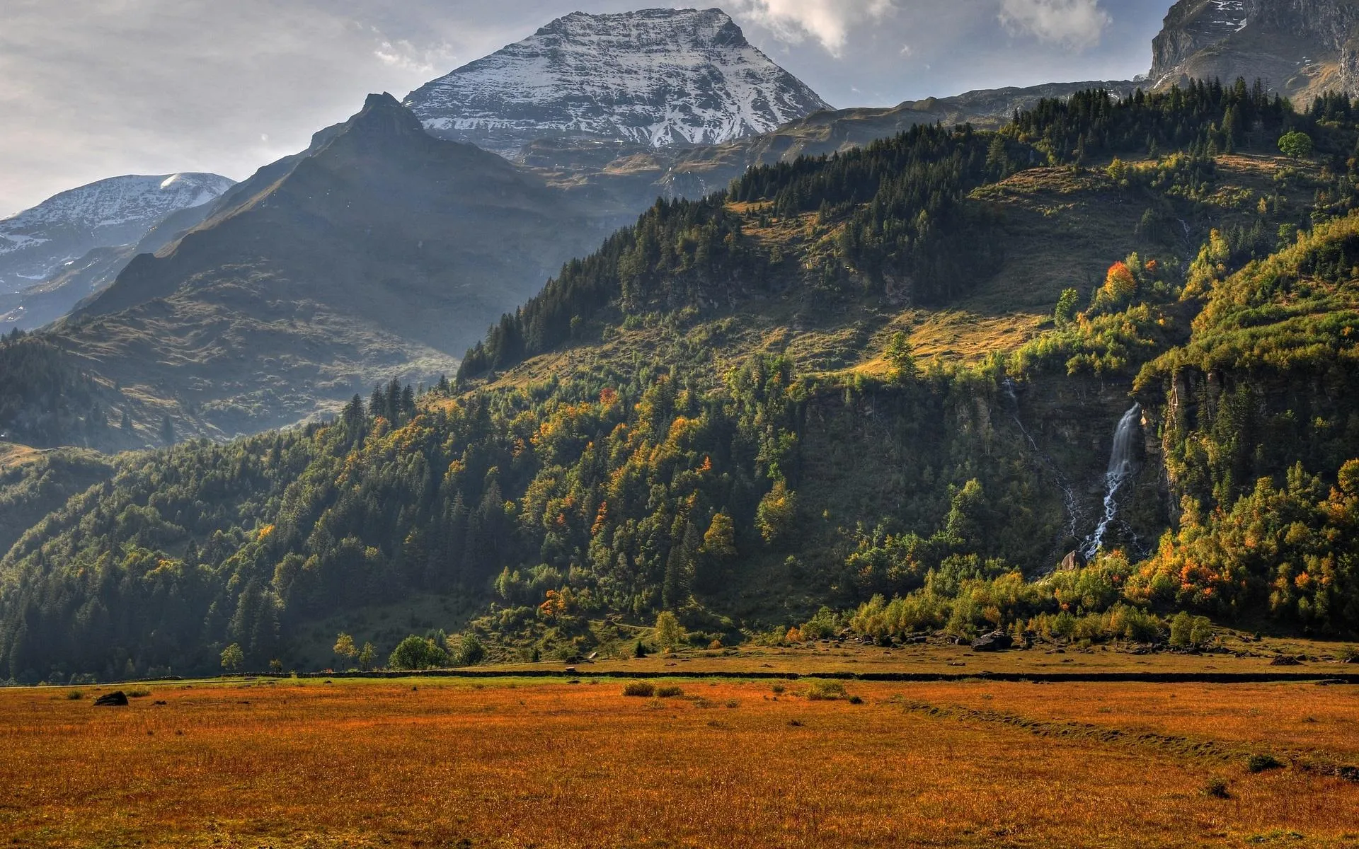 Peaceful Green Hills Beneath Towering Majestic Peaks
