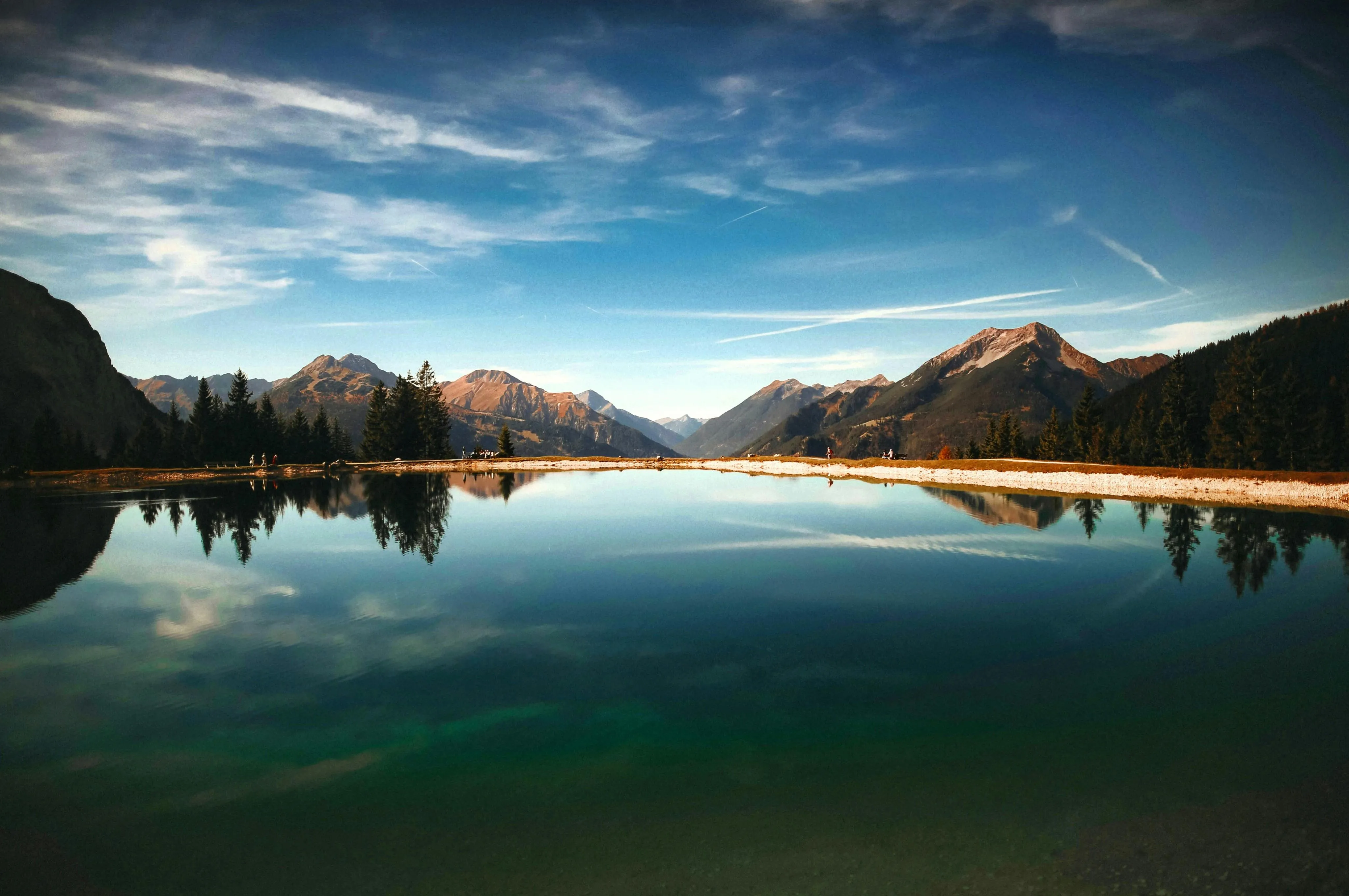 Peaceful Lake Reflecting Blue Sky and Mountain Clouds