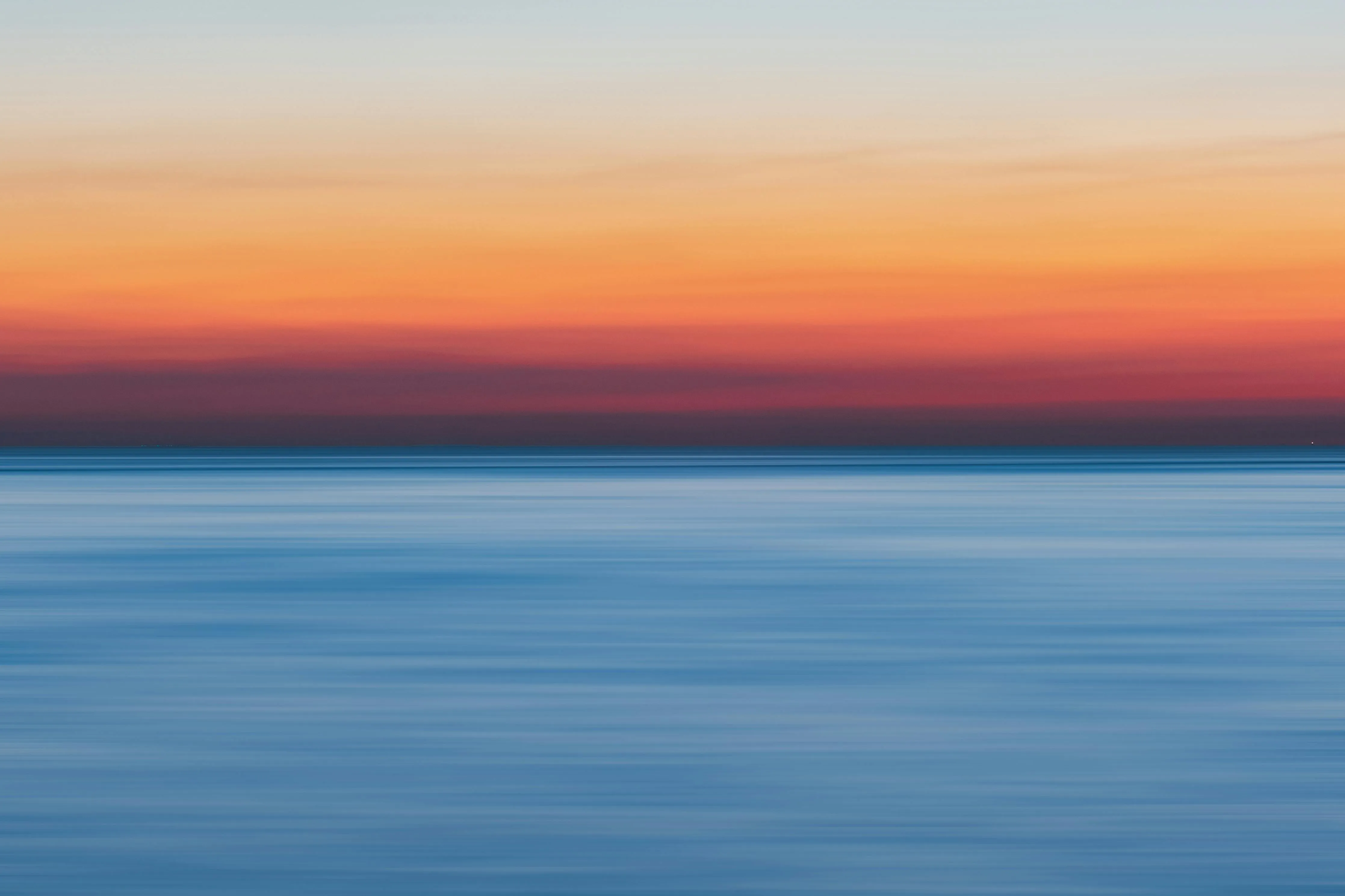 Peaceful Ocean Horizon at Sunset with Soft Cloud Cover