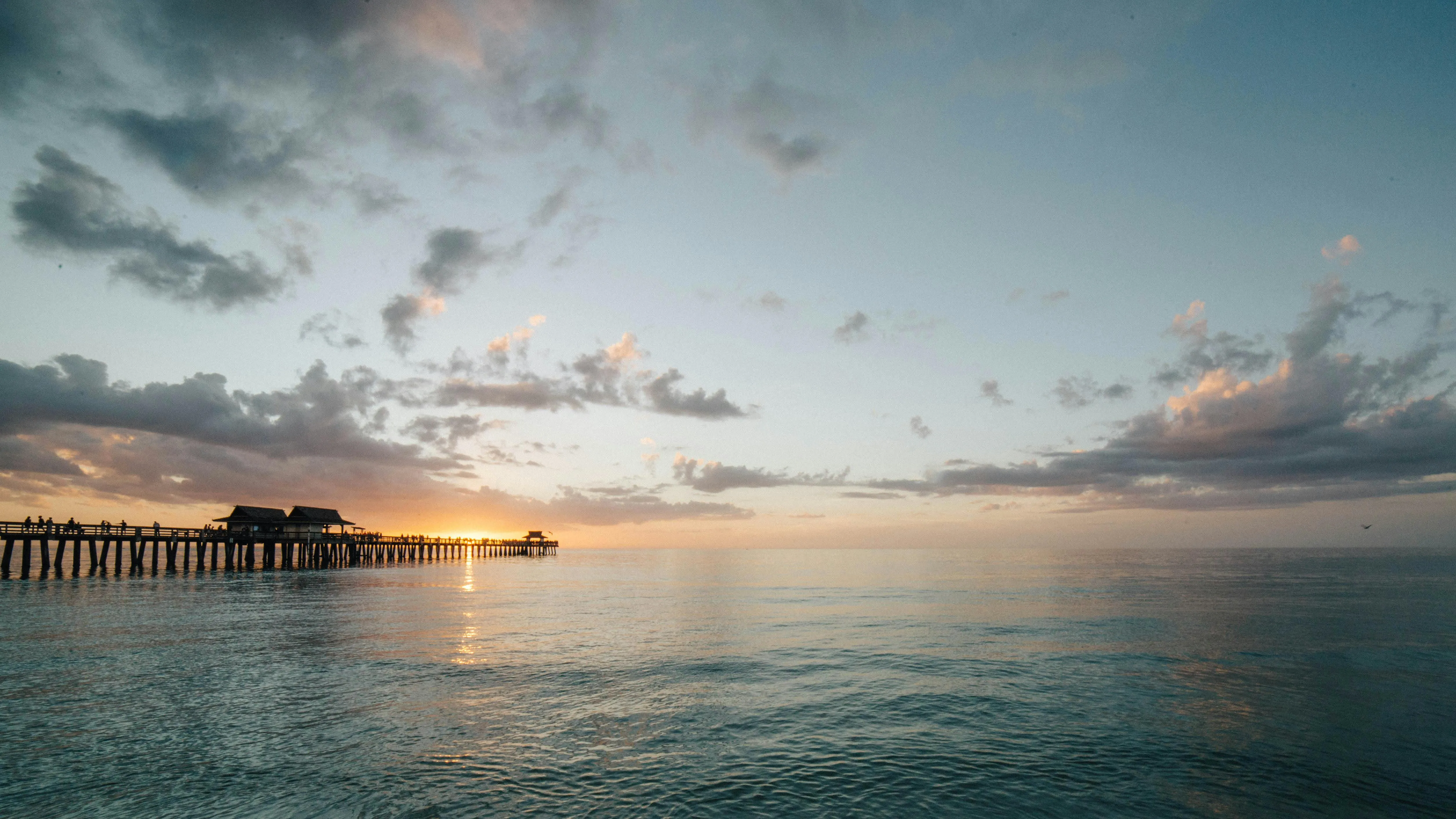 Peaceful Pier Over Water with Colorful Cloudy Sky Photo