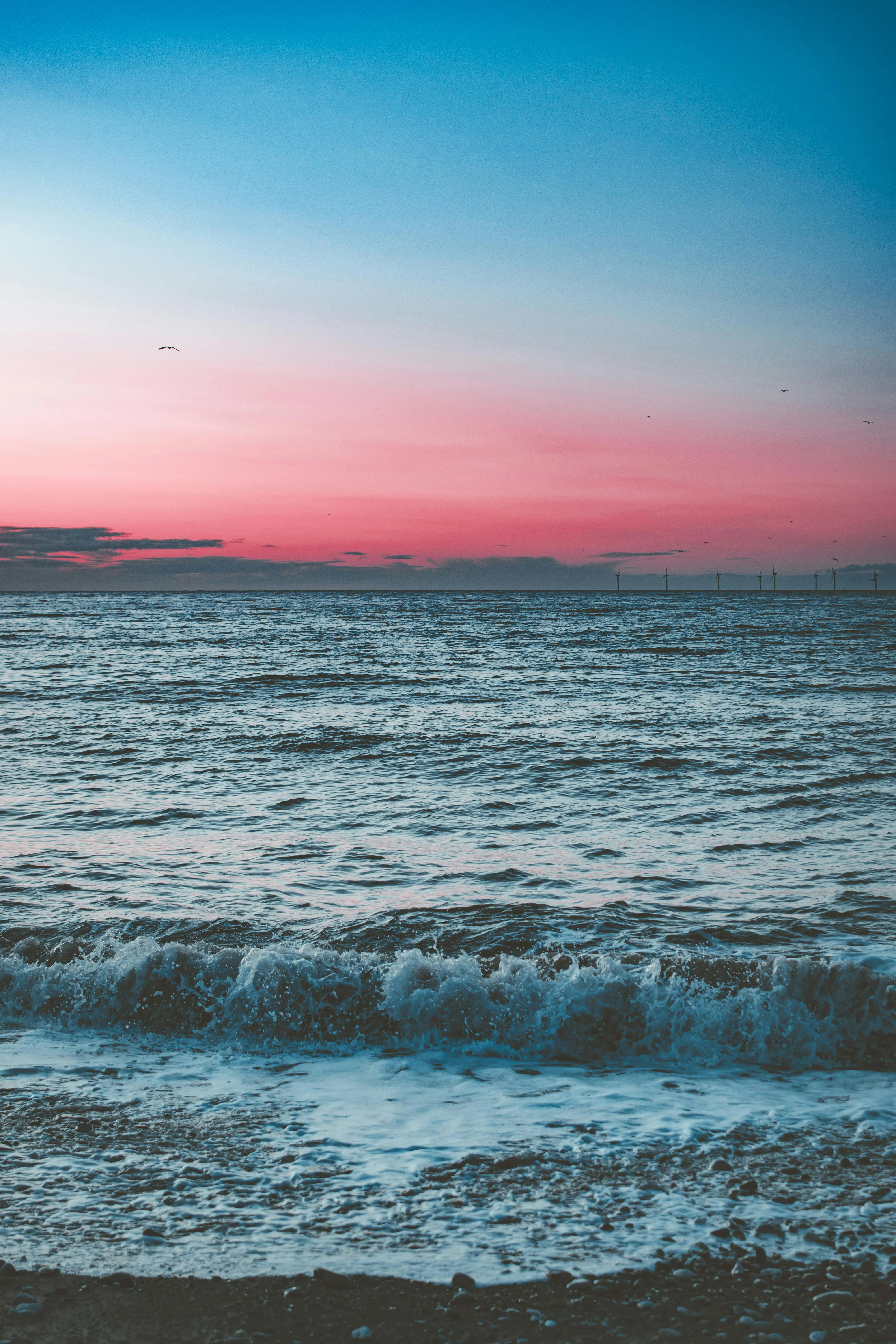 Peaceful Sunset Over Calm Sea with Gentle Clouds Wallpaper