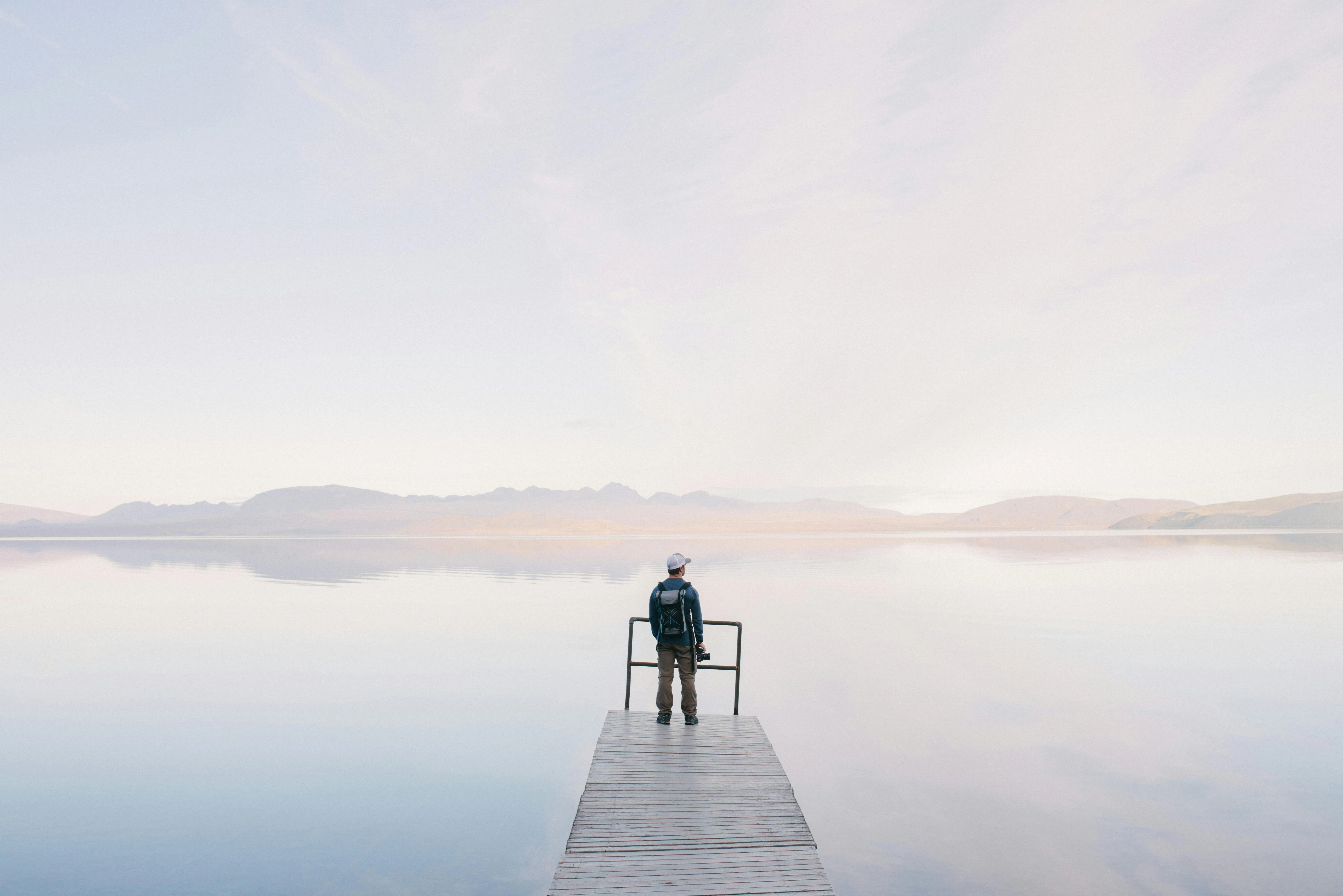 Person on Pier Under Calm Sky and Gentle Morning Light