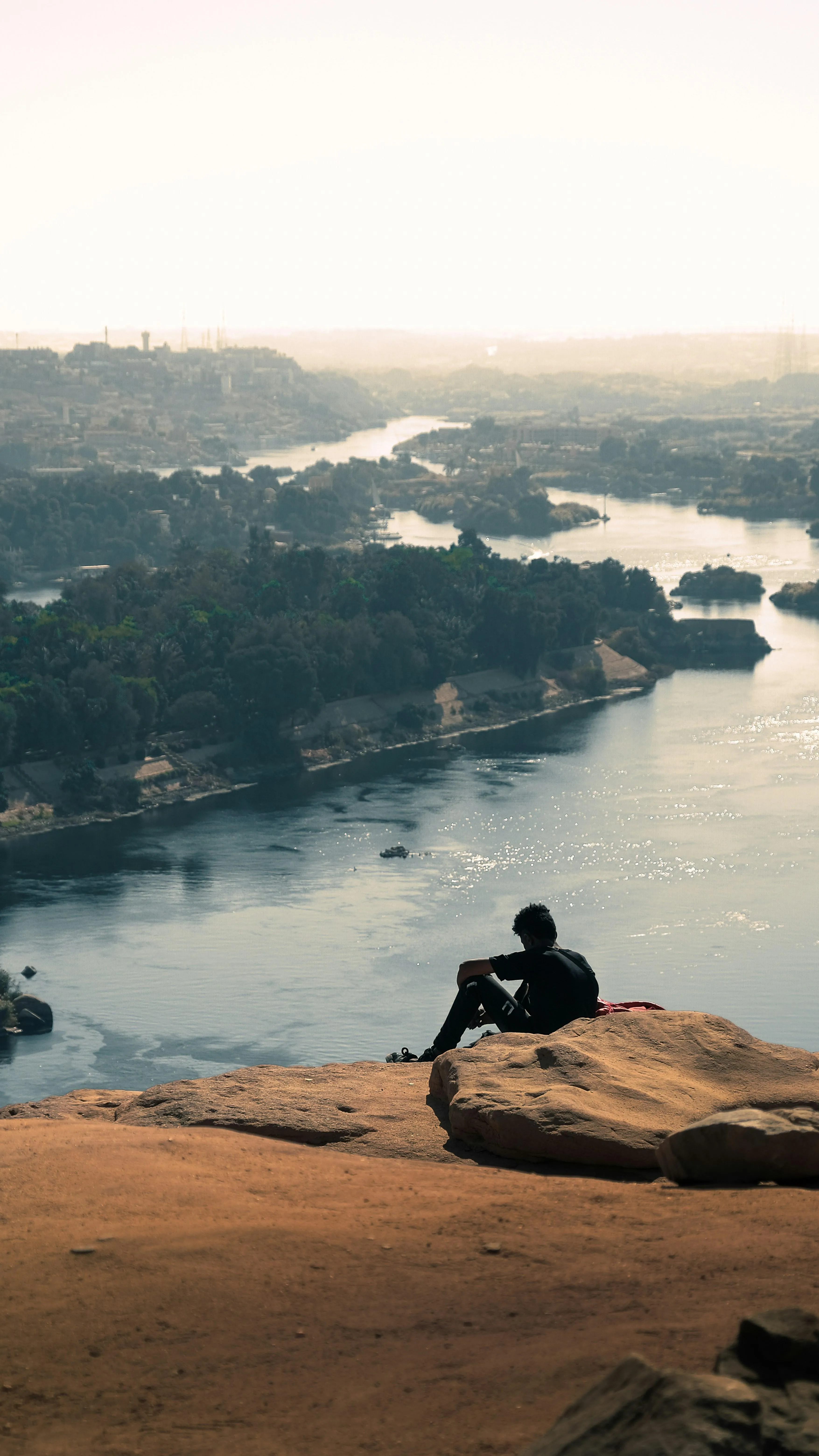 Person Sitting on Rock Above Cloudy Mountain Valley
