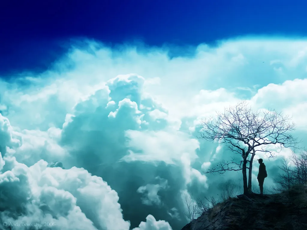 Person Standing on Cliff Surrounded By Thick White Clouds