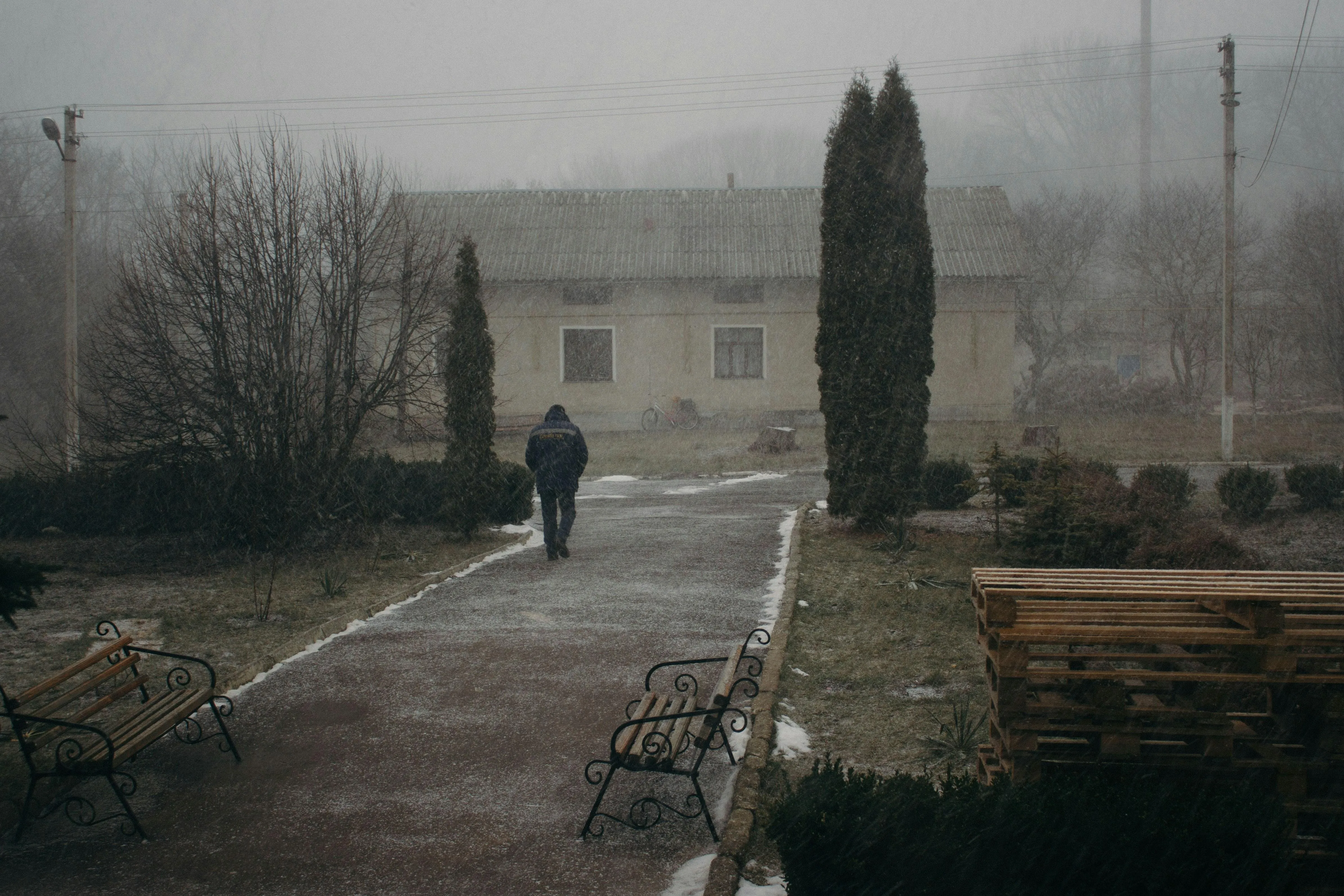 Person Walking Alone in Misty Rain Covered Street Wallpaper