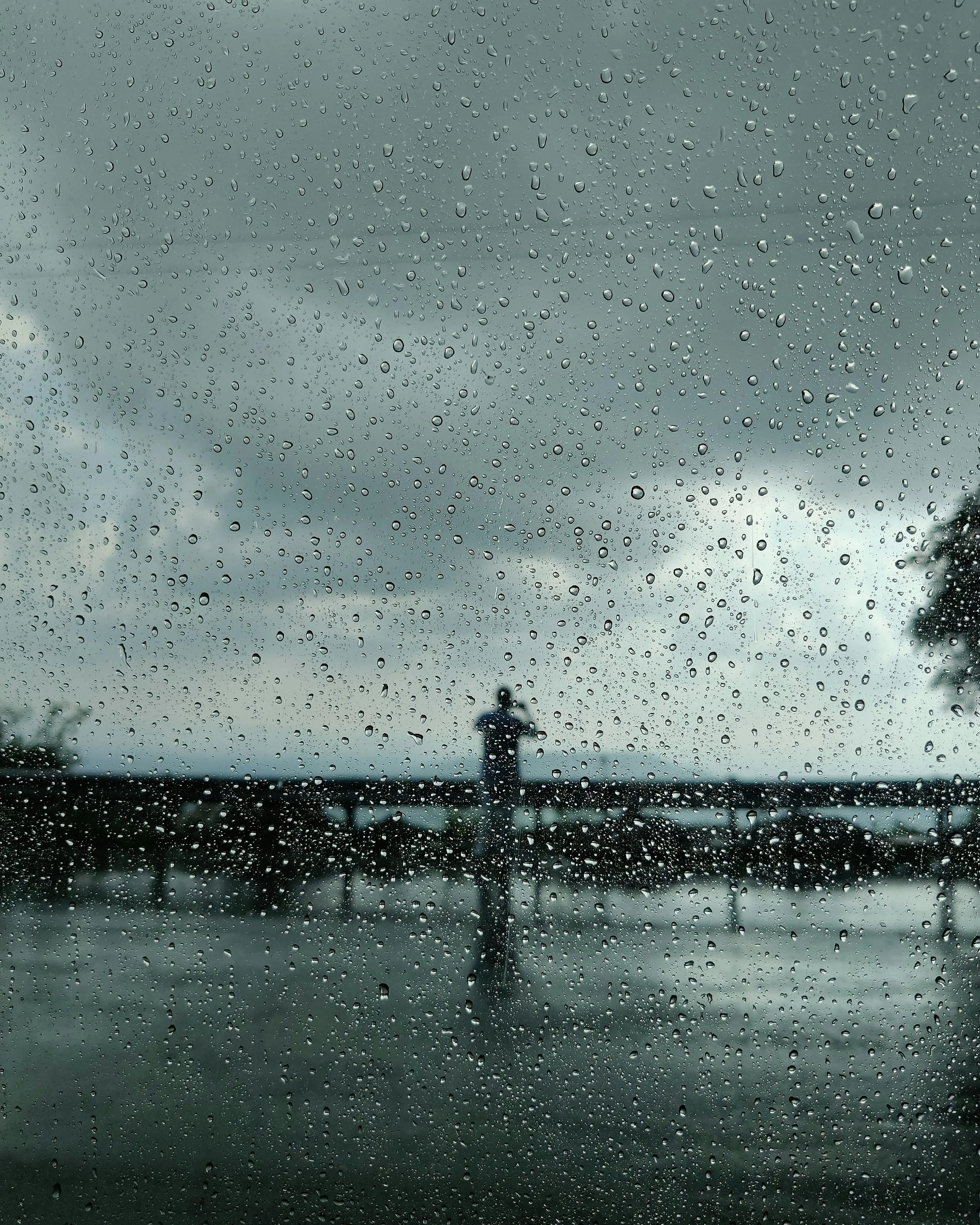 Person Walking on Bridge in Rain with Umbrella Wallpaper