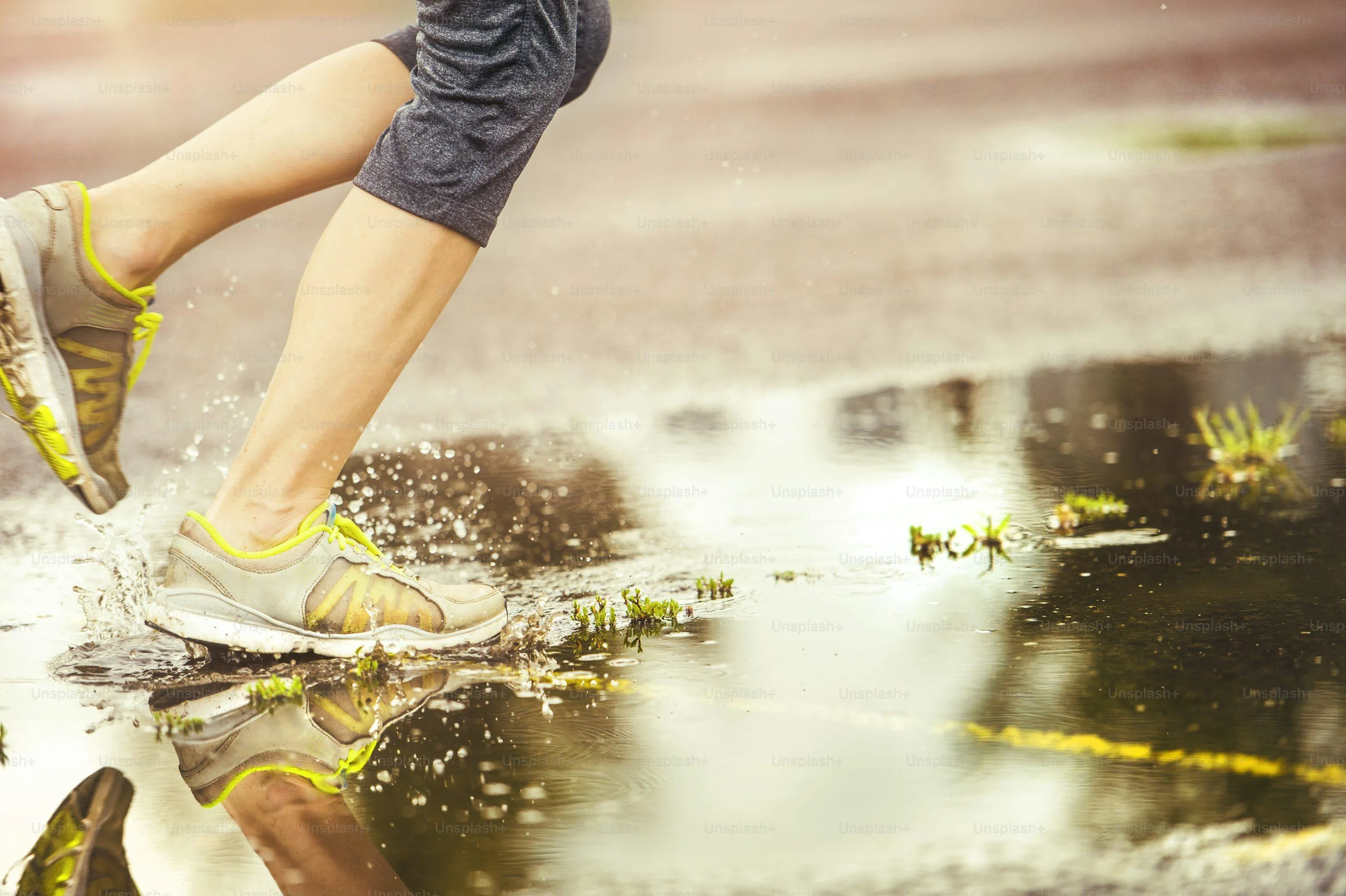 Person Walking on Wet Pavement with Blurred Rain Splashes