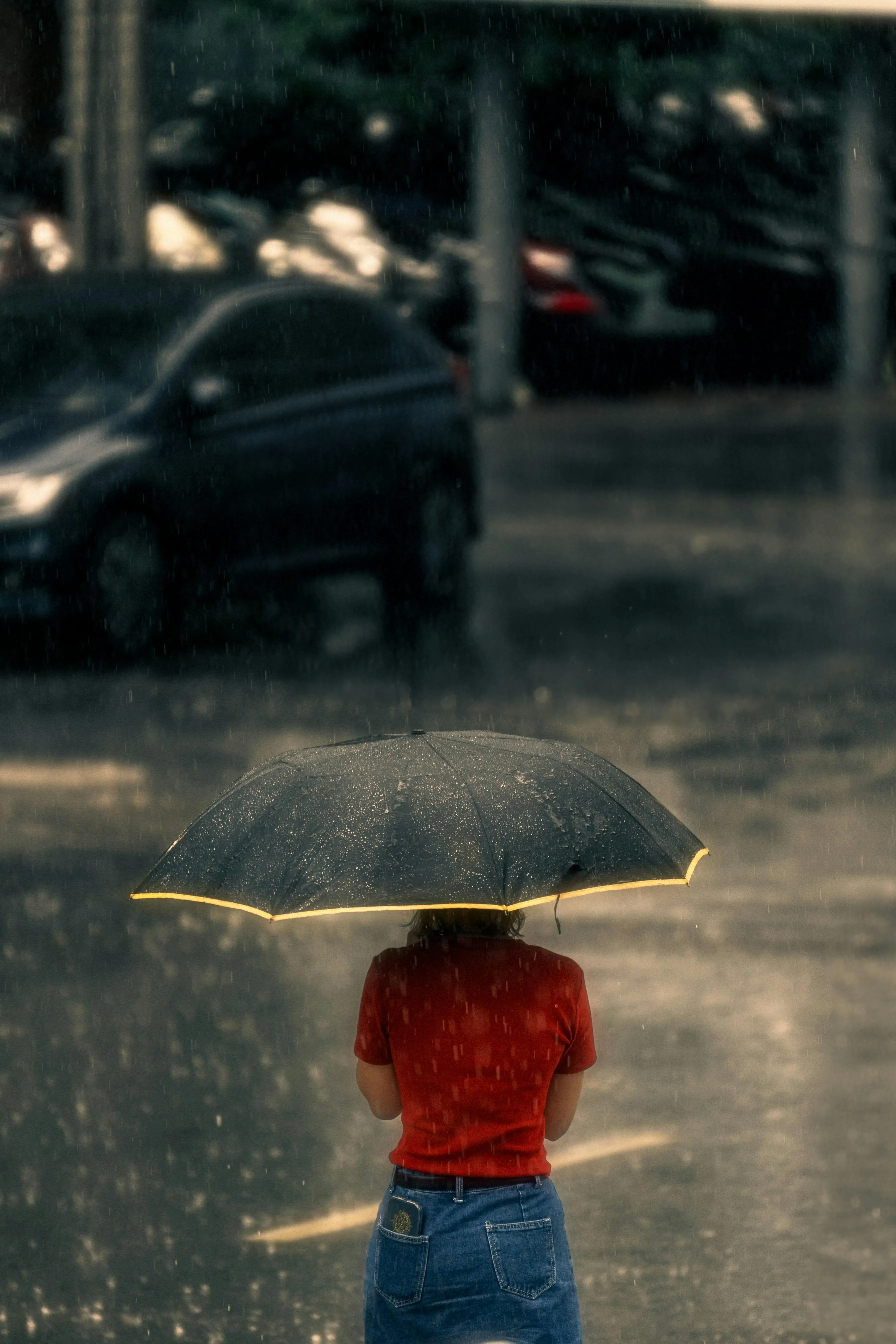 Person Walking with Umbrella on Wet City Sidewalk