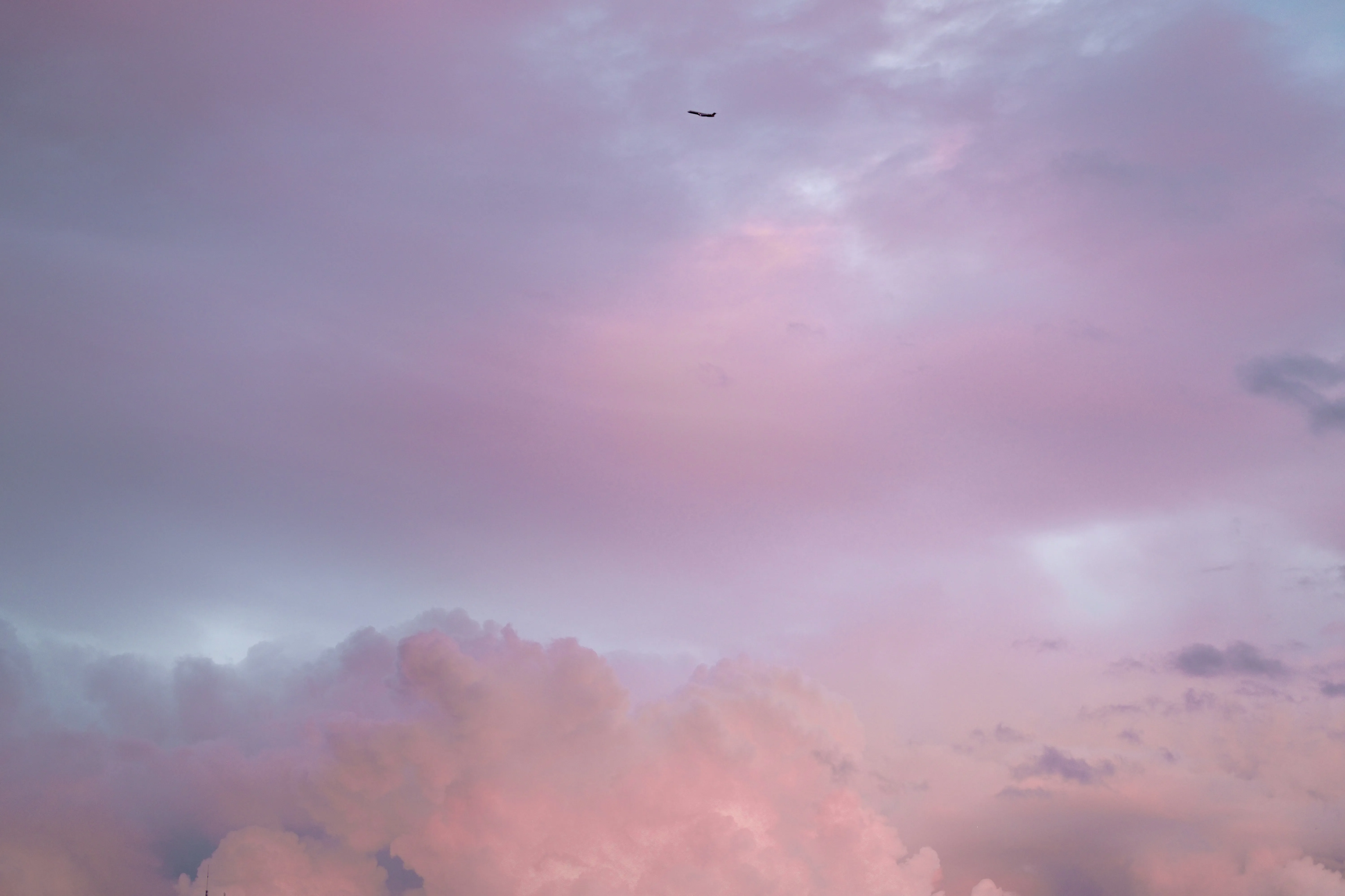 Pink and Purple Clouds Against Soft Blue Sky with Birds