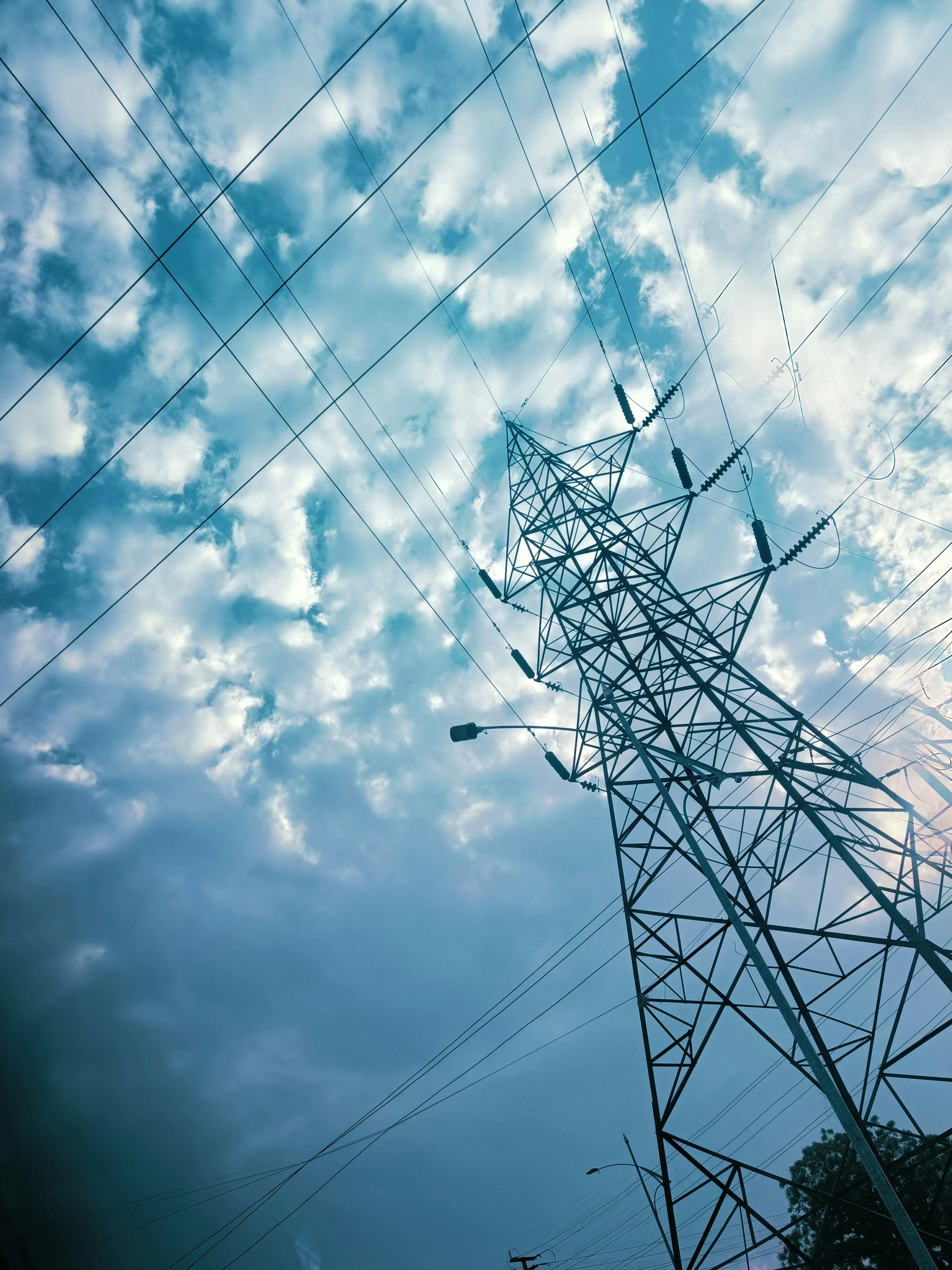 Power Lines Tower Against Bright Blue Sky with Birds Flying