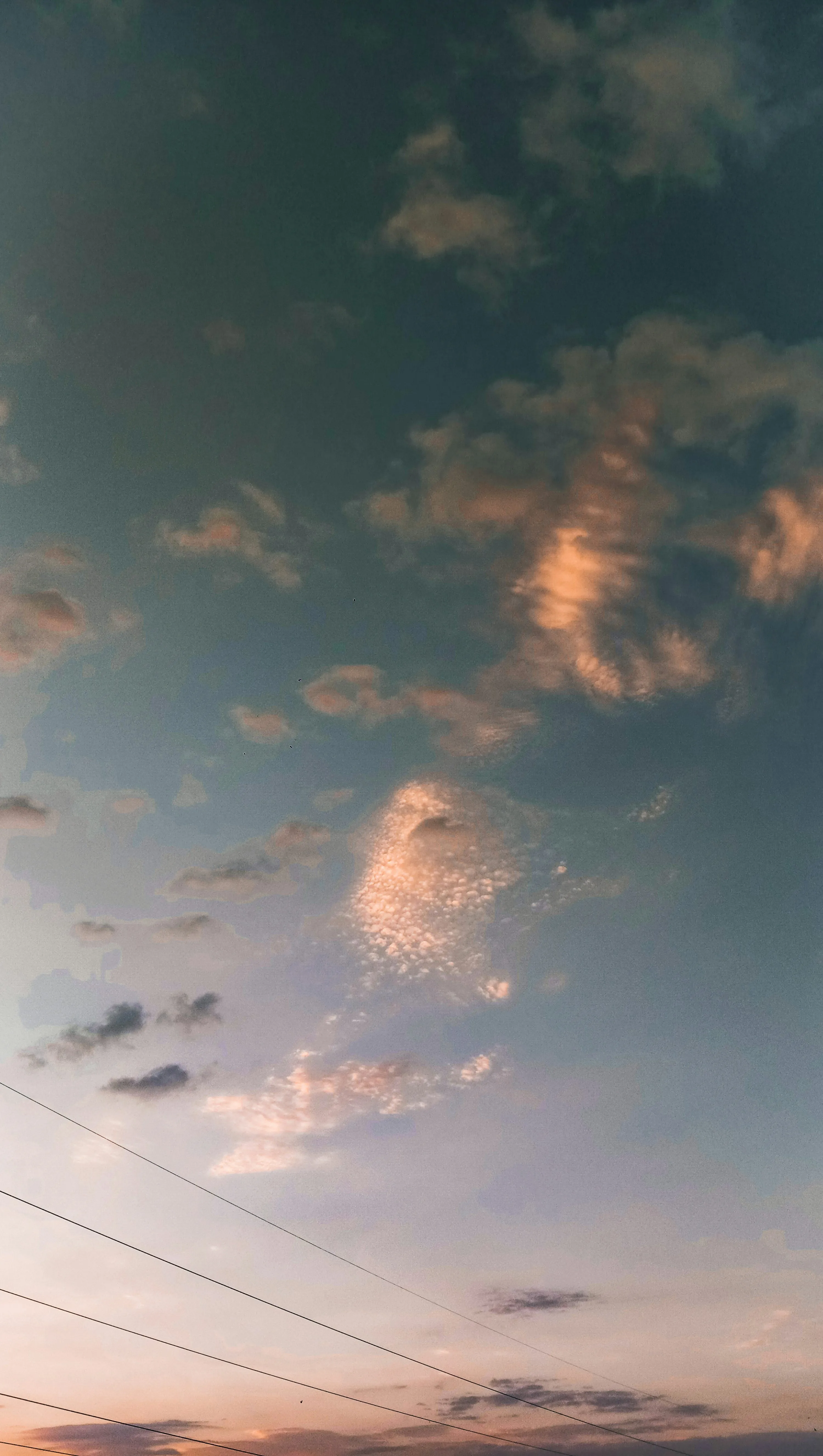 Power Lines Under Evening Sky with Golden Scattered Clouds