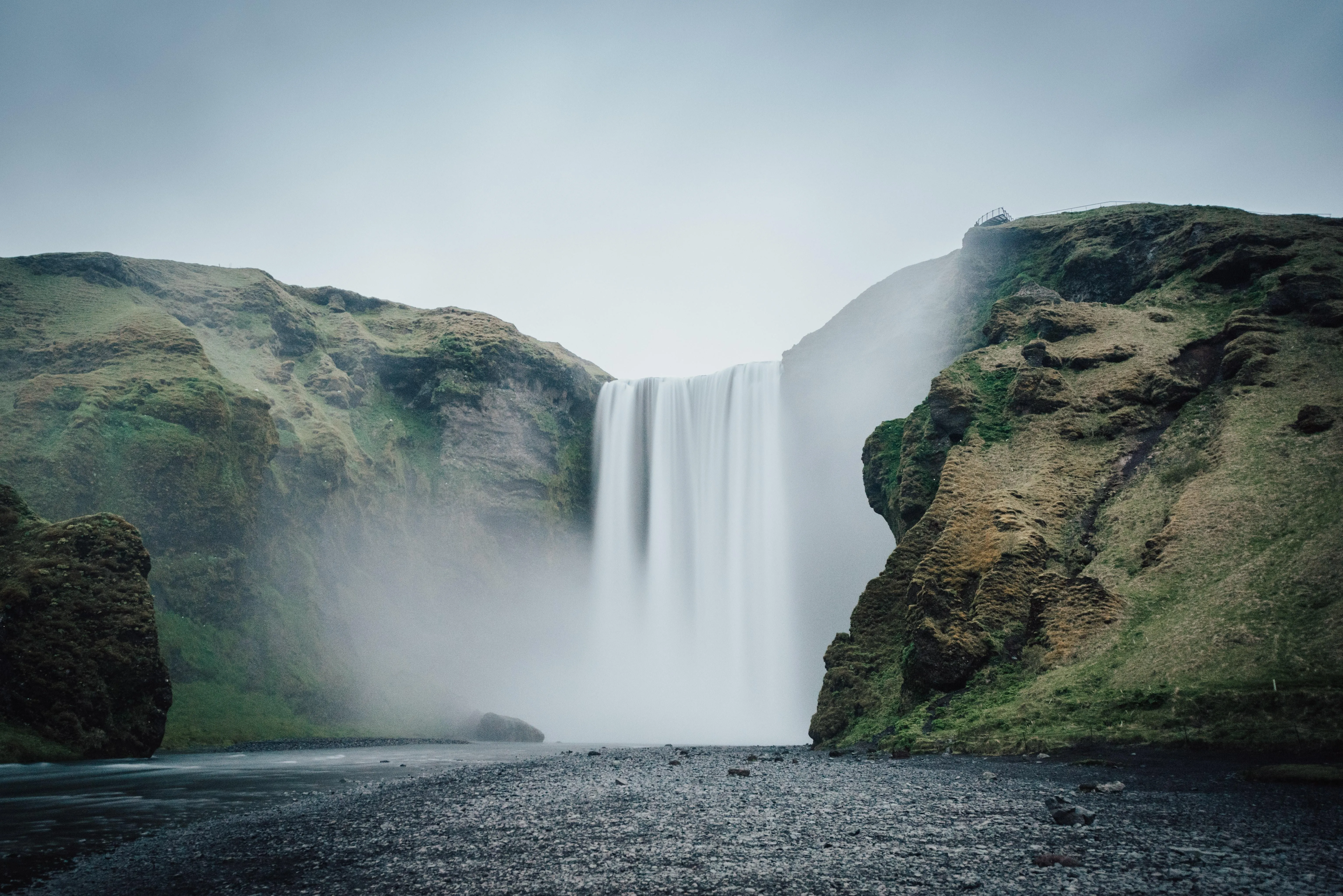 Powerful waterfall flowing down rocky cliffs HD image