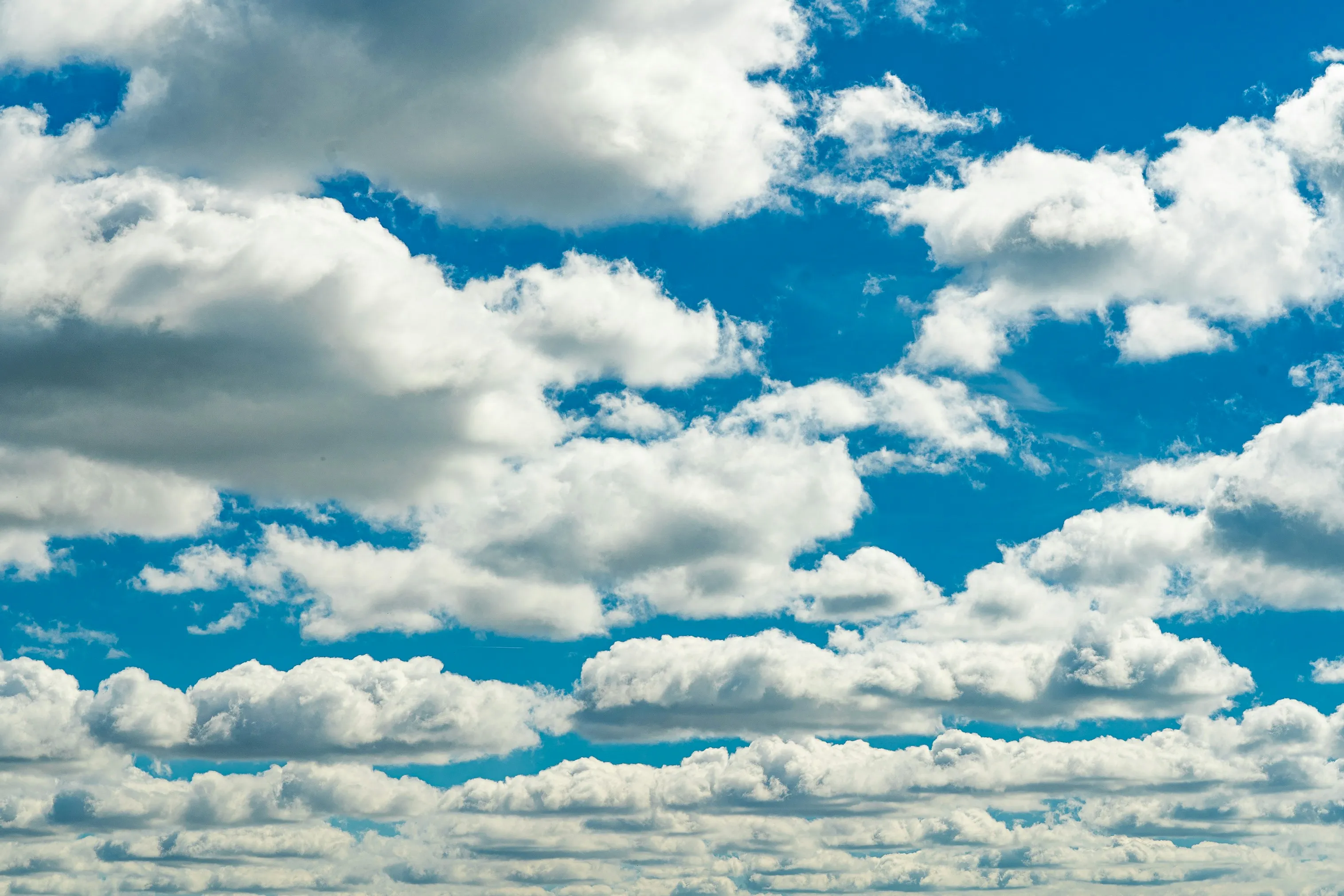 Puffy Cumulus Clouds in Clear Bright Blue Summer Sky