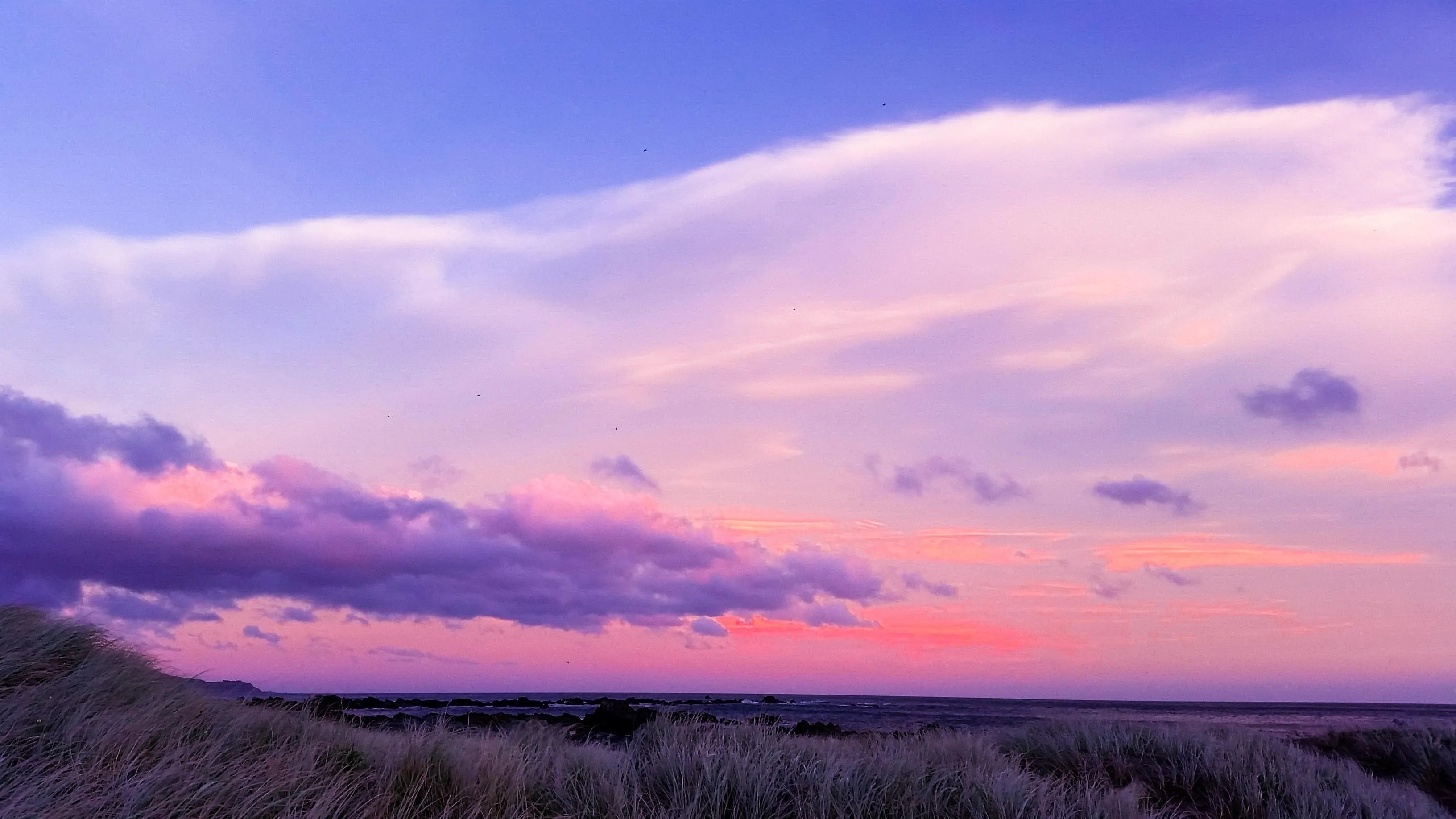 Purple and Pink Clouds Floating in a Tranquil Sky Wallpaper