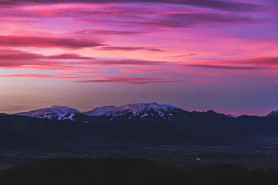 Purple and Pink Sunset Over Mountain Landscape Scene