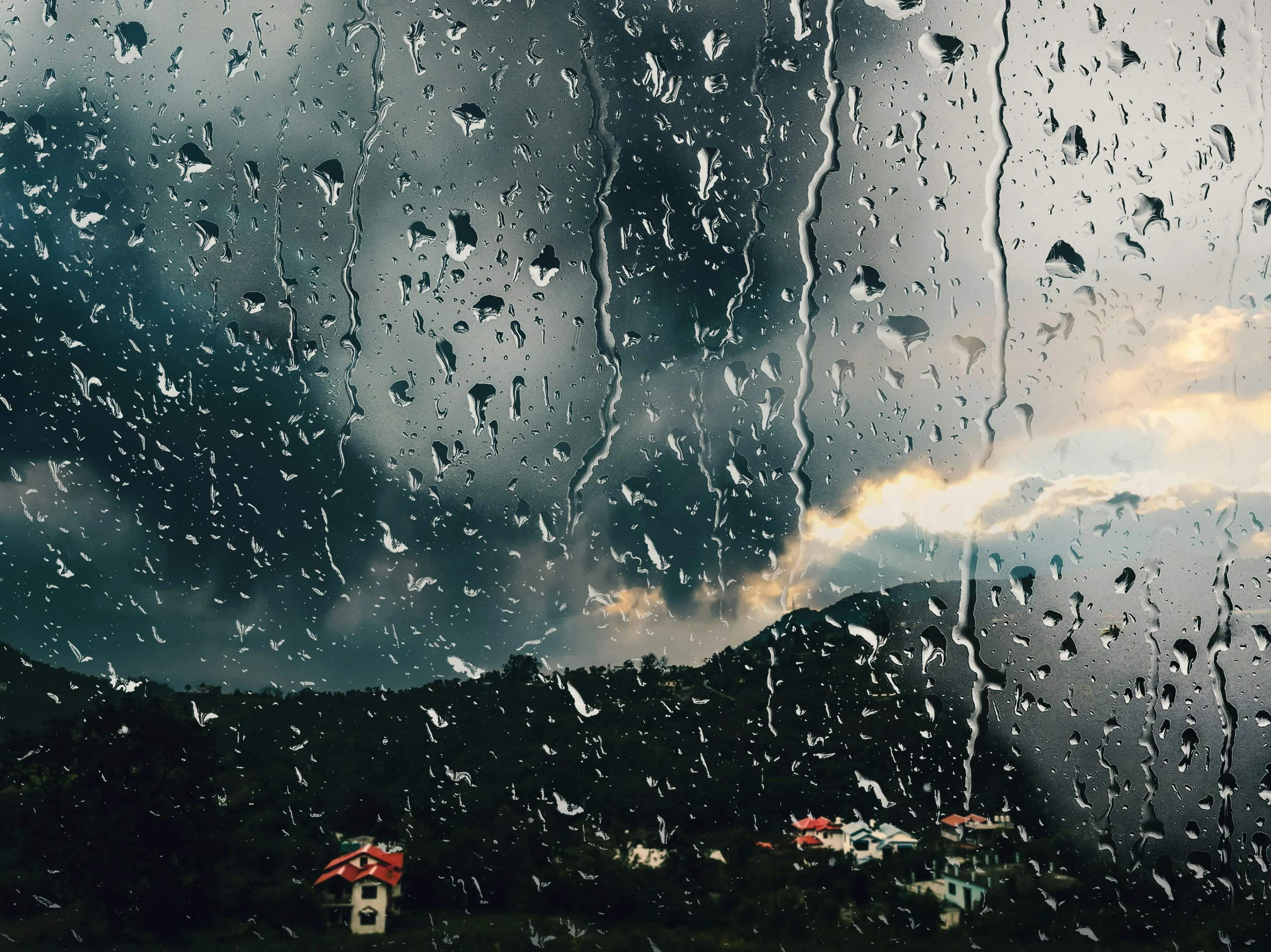 Rain Hitting Window with Dark Clouds Outside Wallpaper