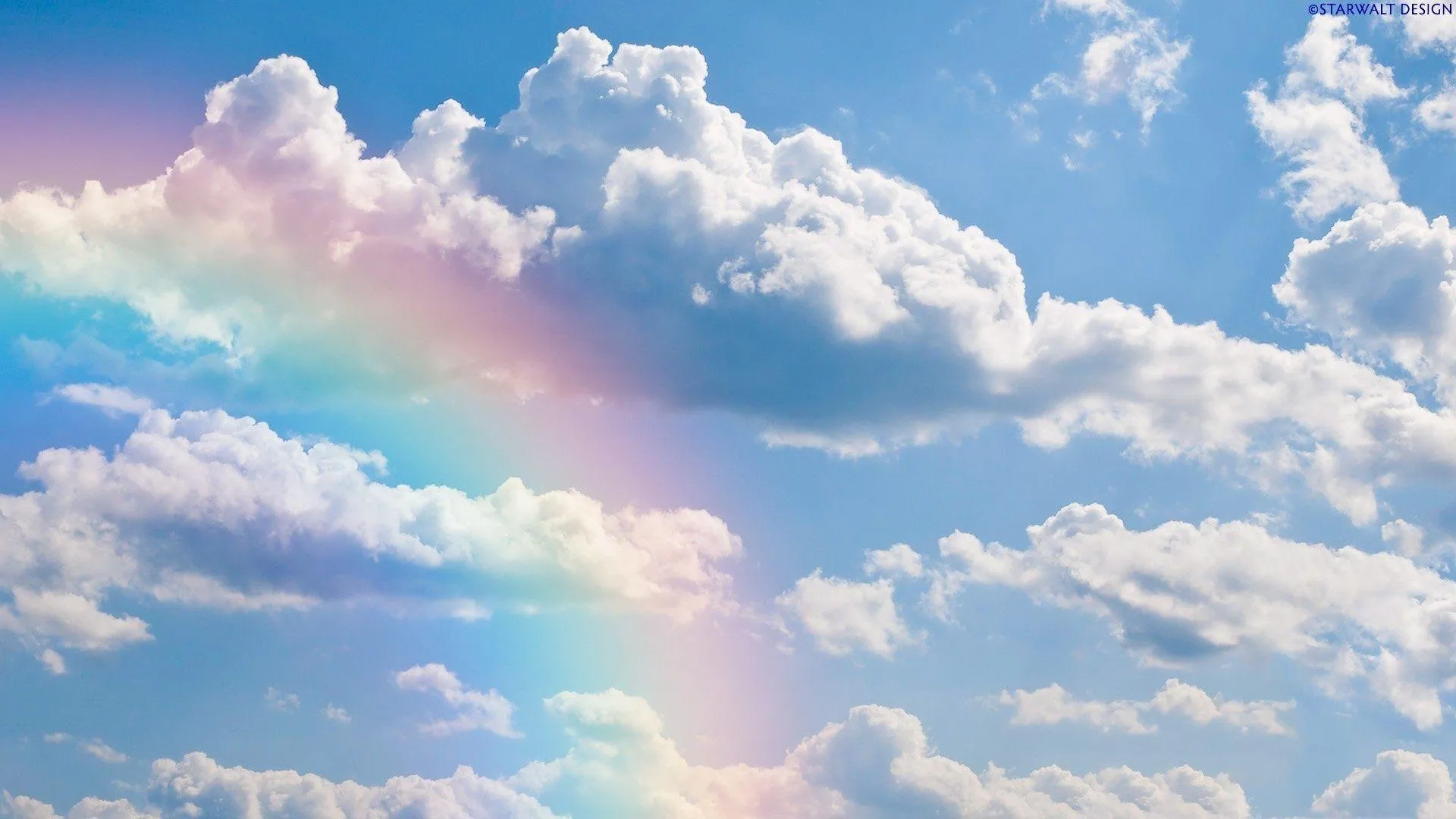 Rainbow Arching Over Puffy Clouds in Blue Sky Wallpaper