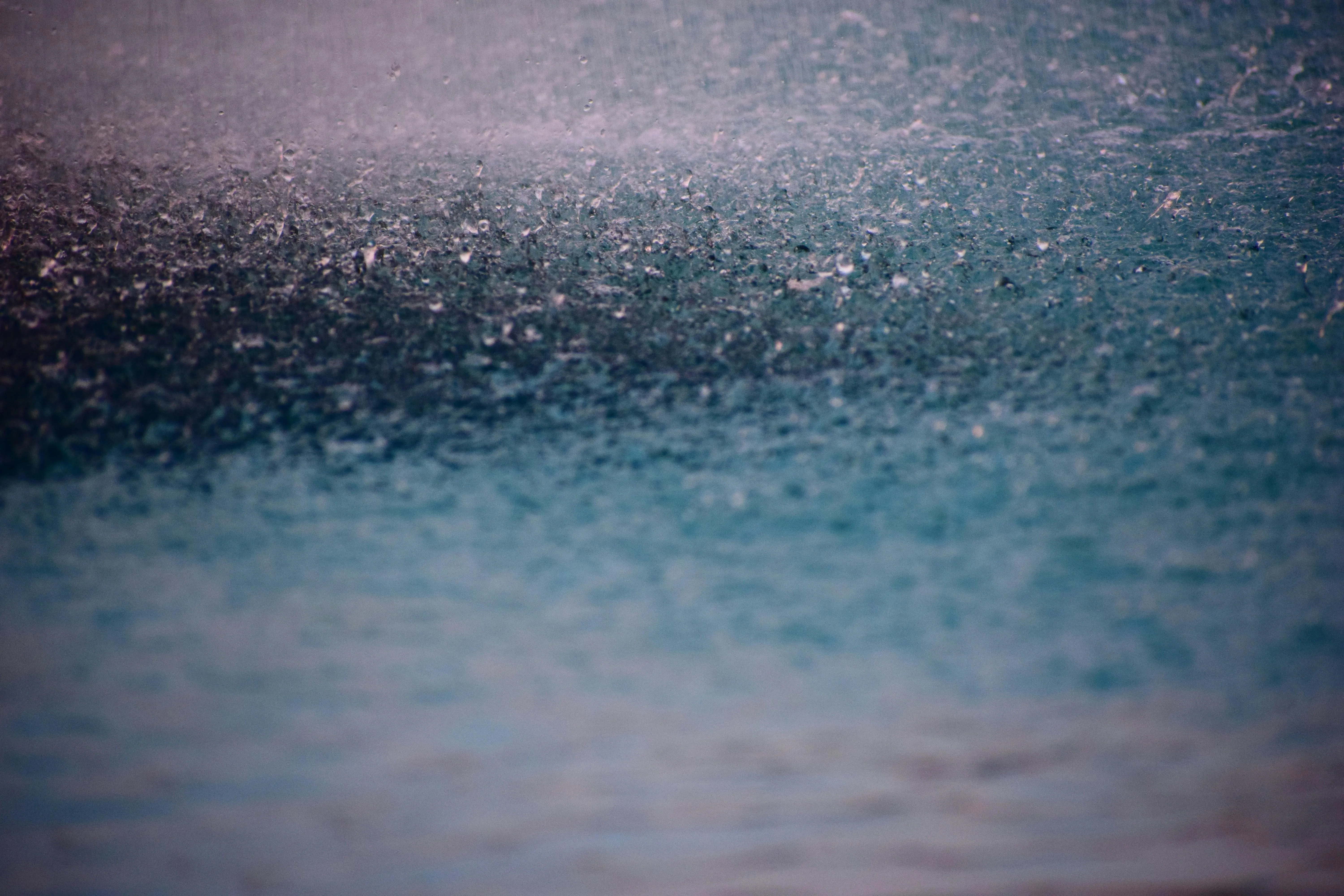 Raindrops Creating Ripples on Dark Blue Surface Image