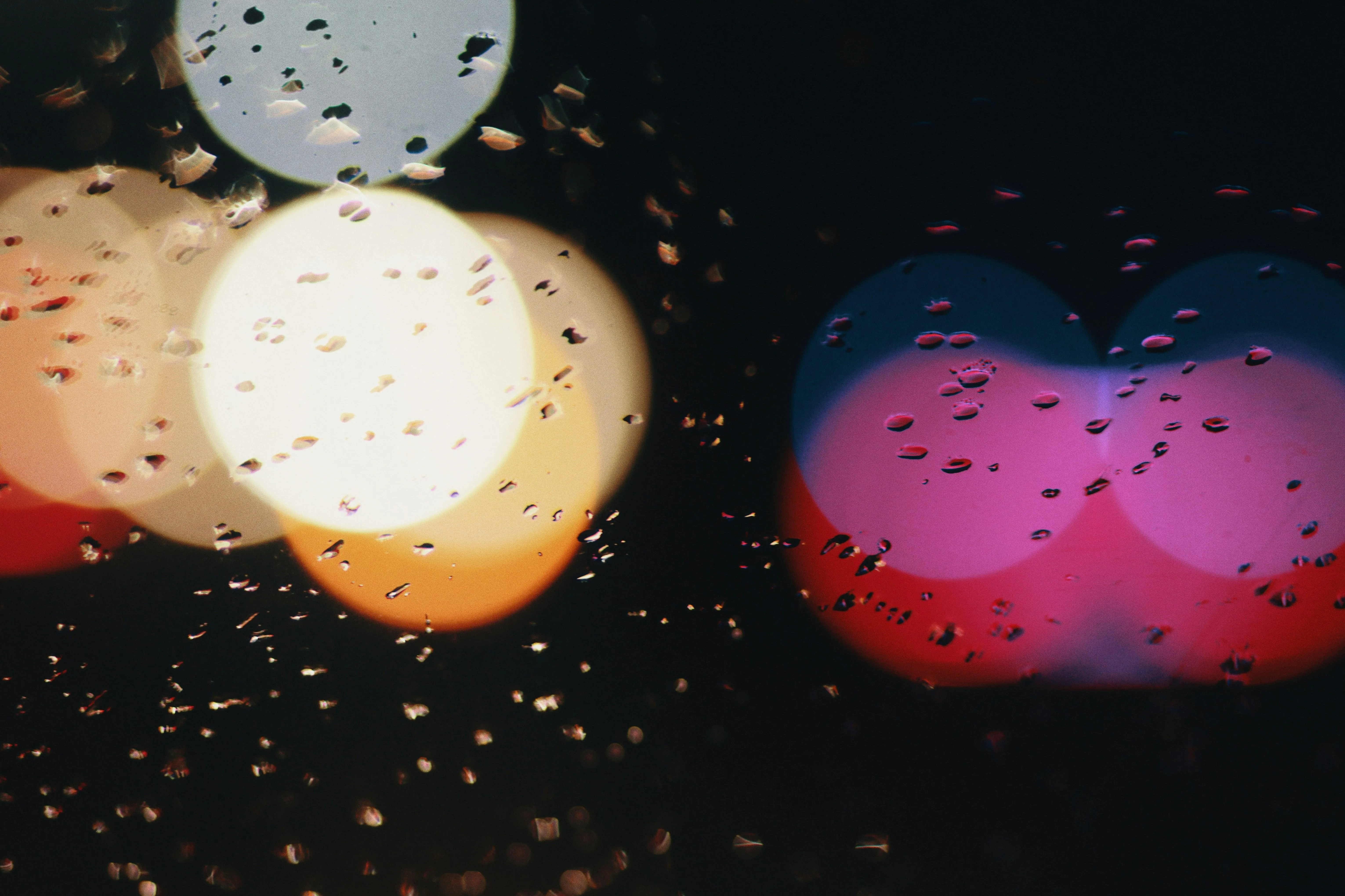 Raindrops on Lens Blurring Street Lights at Night