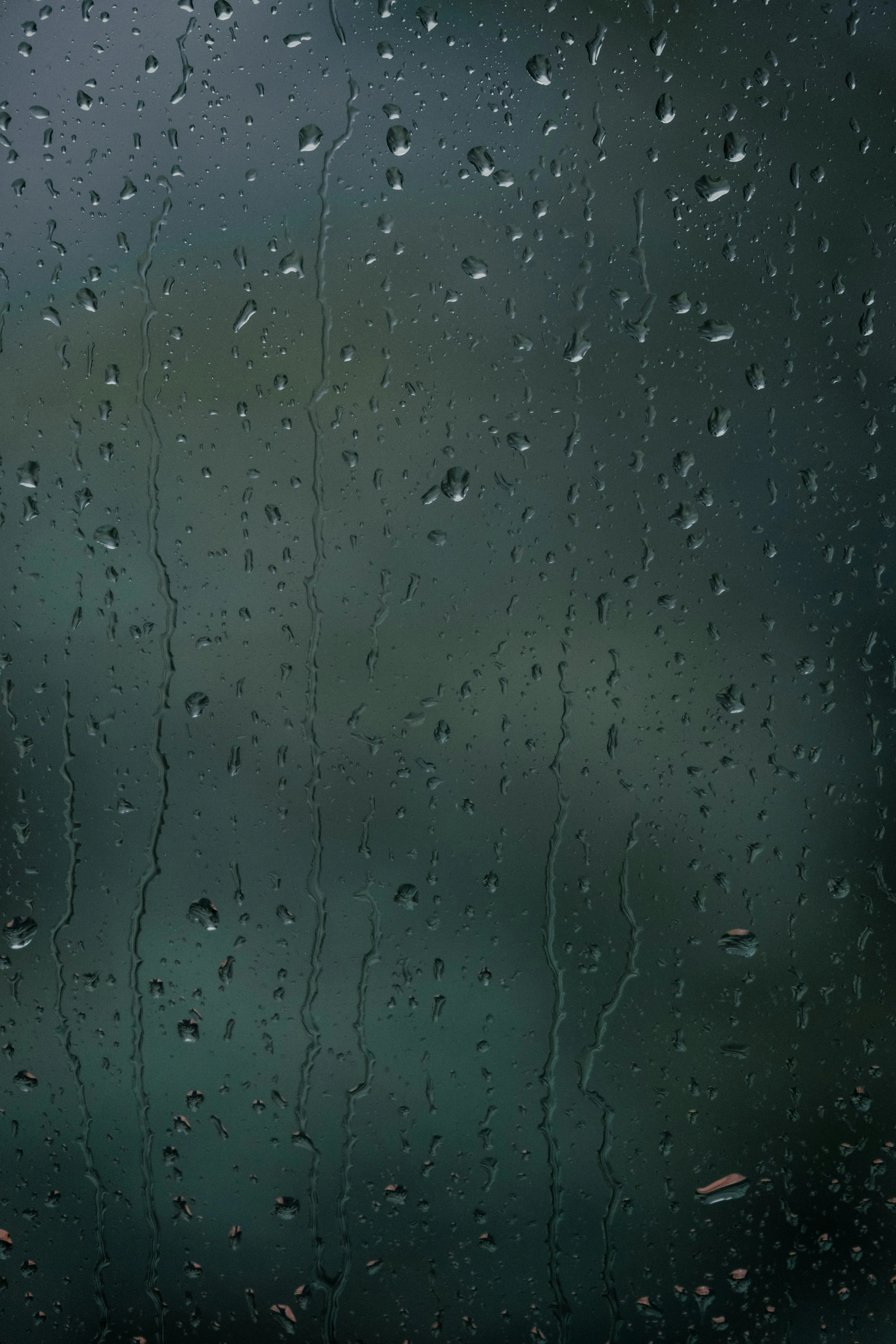Raindrops on Window Overlooking Blurred Green Trees