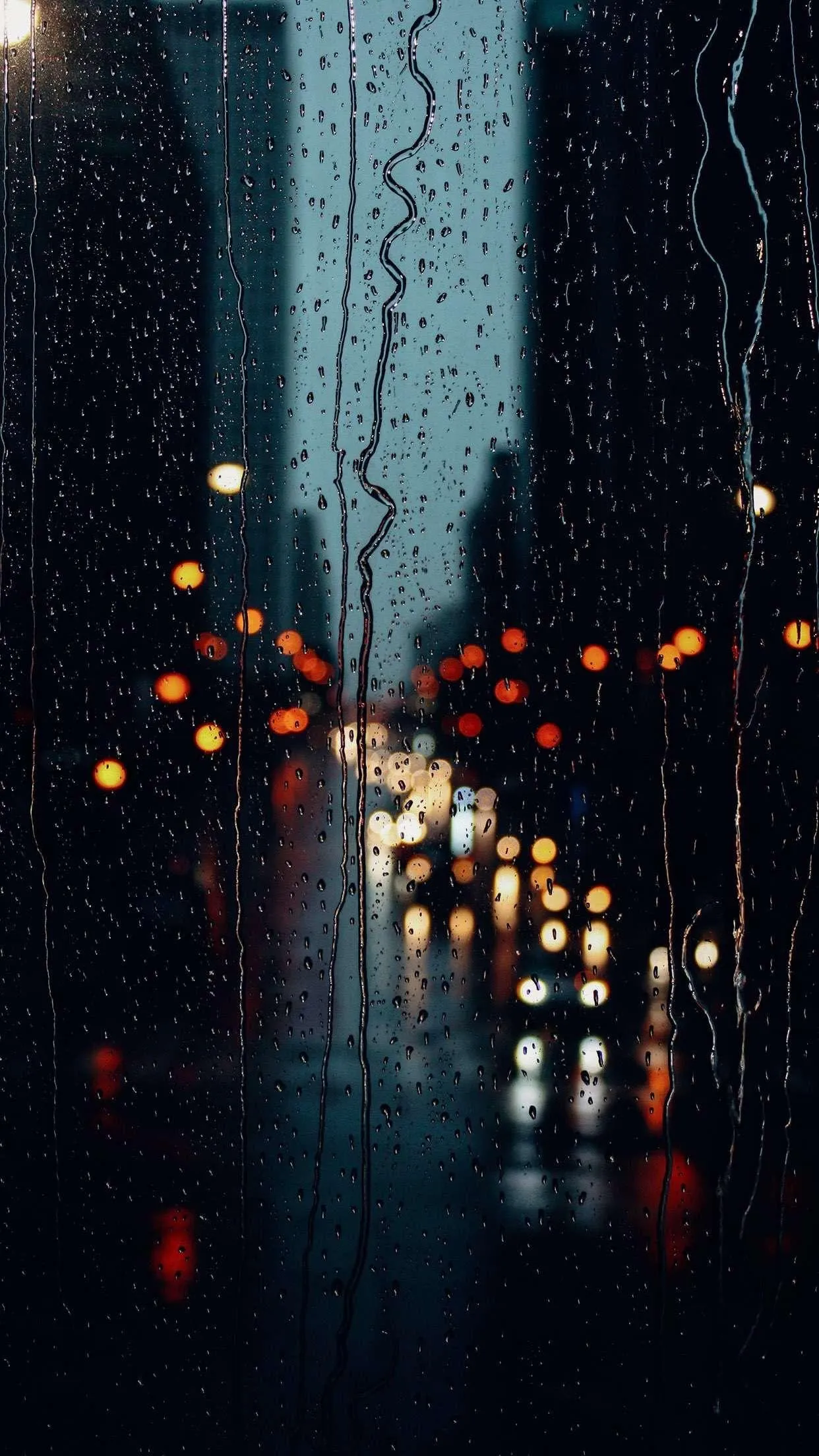 Raindrops on Window Reflecting Orange Streetlights