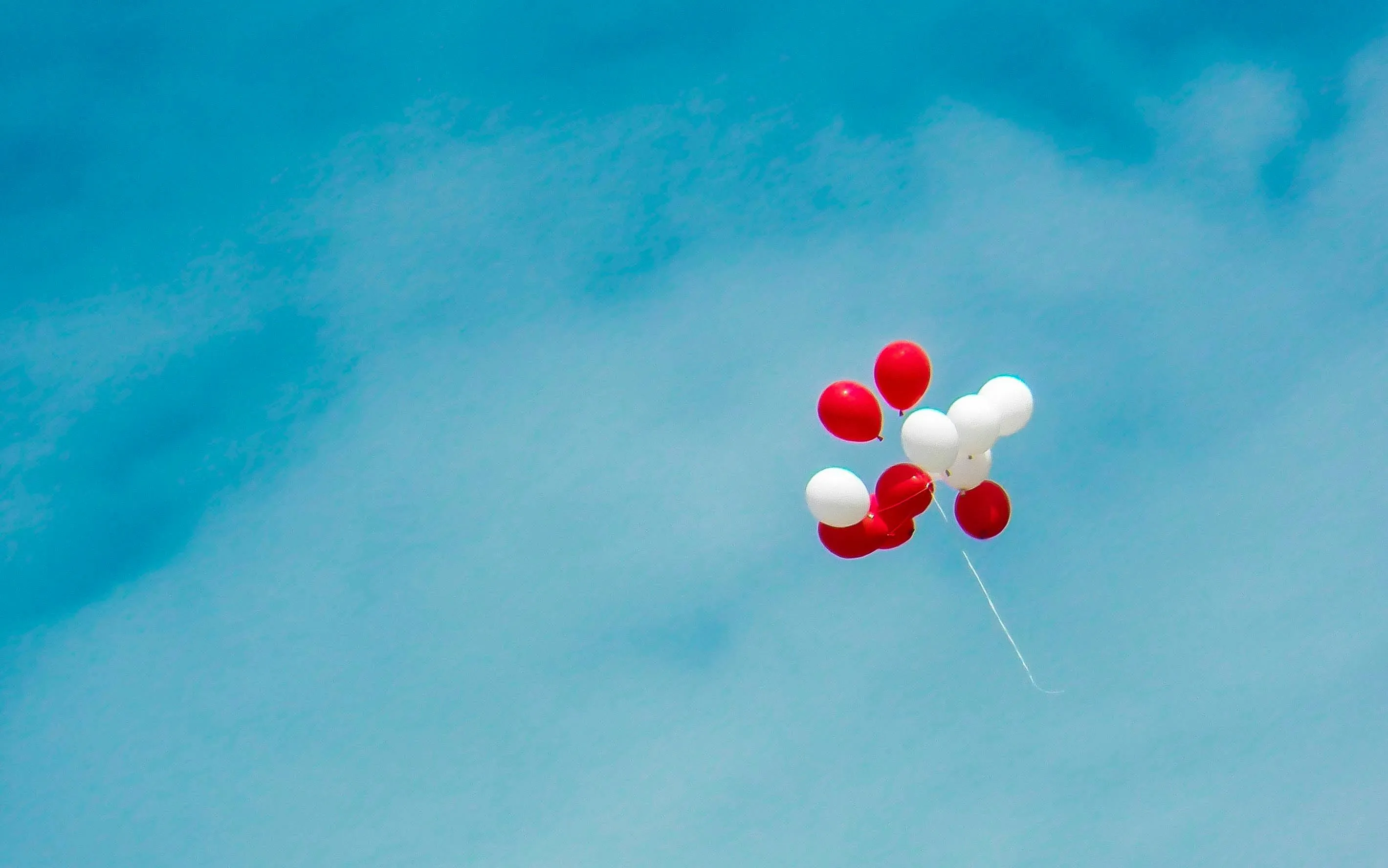 Red and White Balloons Floating Gently in Blue Sky Wallpaper