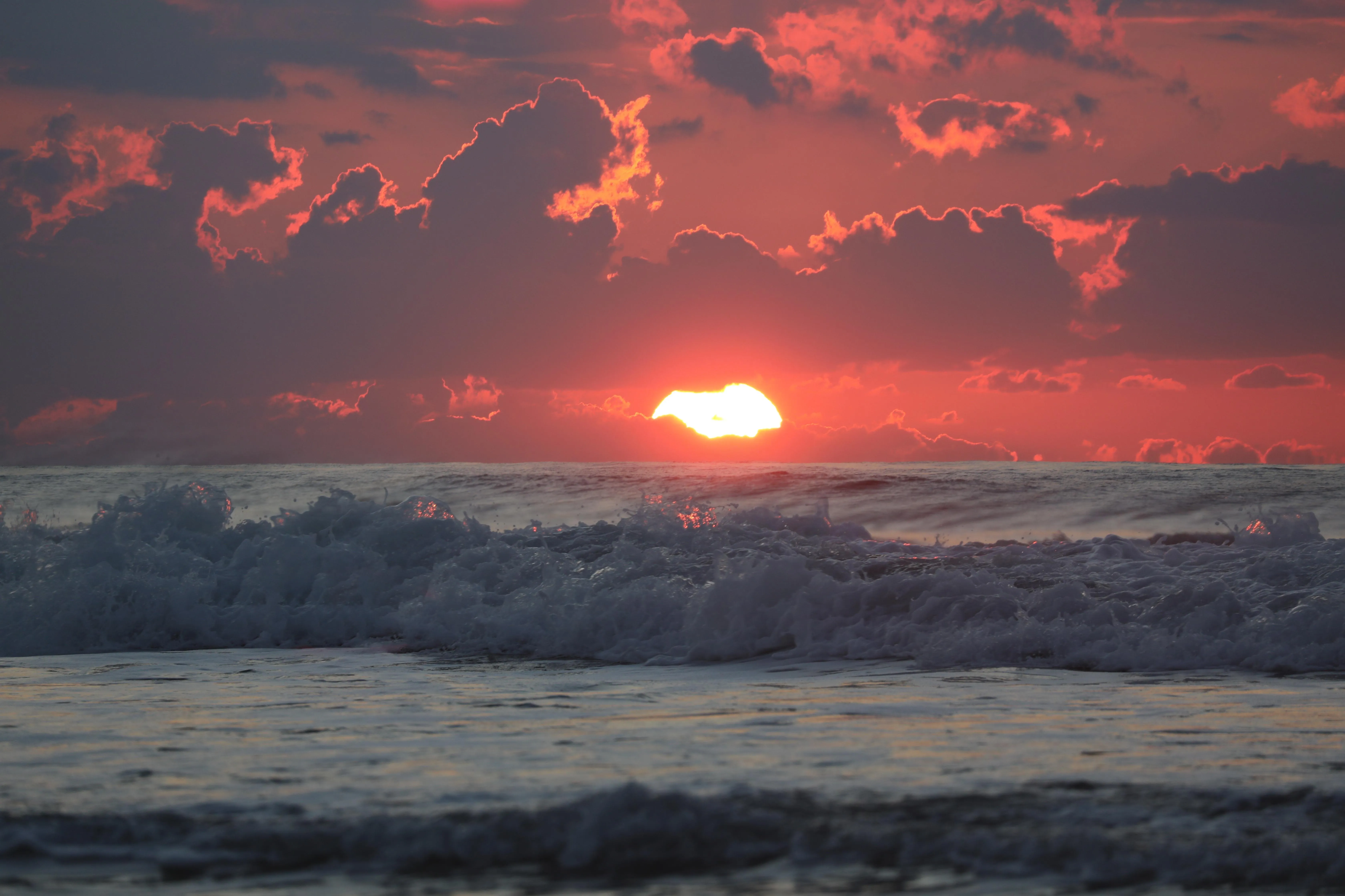 Red sunset over ocean with dramatic clouds free HD image