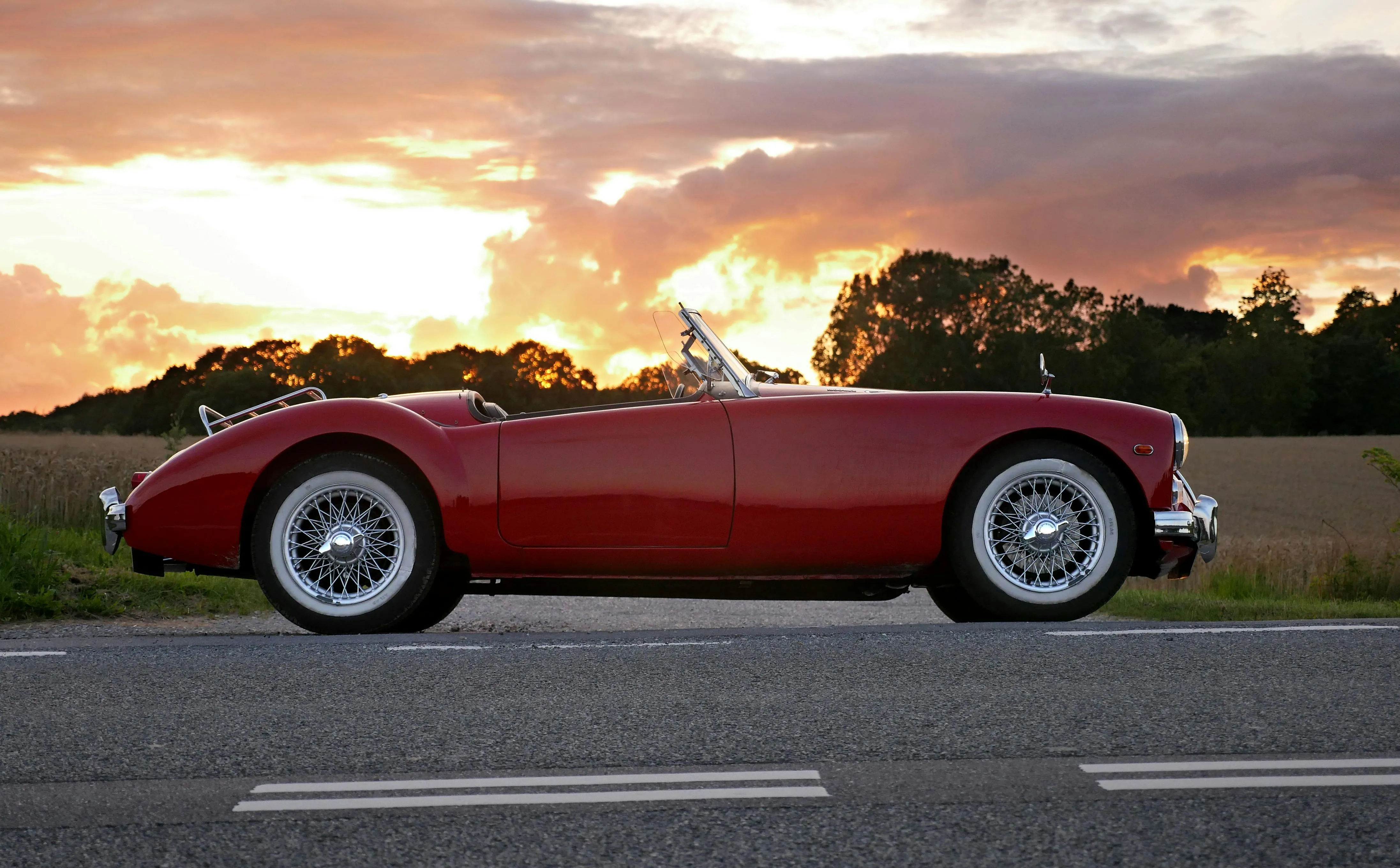Red Vintage Convertible Car Parked at Sunset Roadside