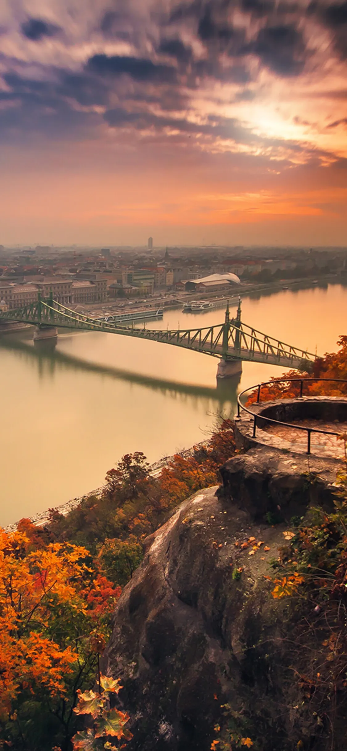 River Bridge At Sunset Near a Forested City Hillside