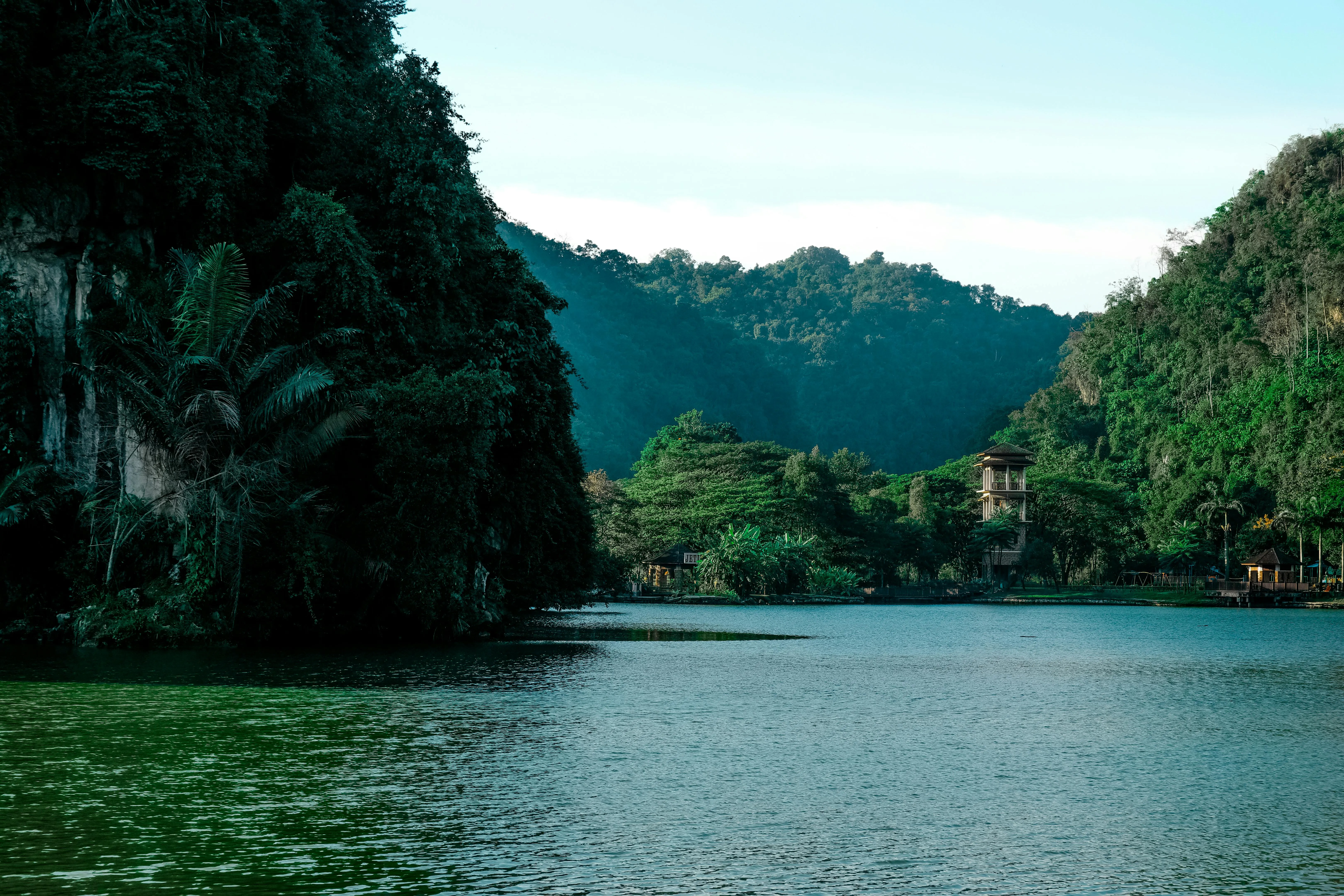 River Flows Between Rocky Green Hills and Green Forests