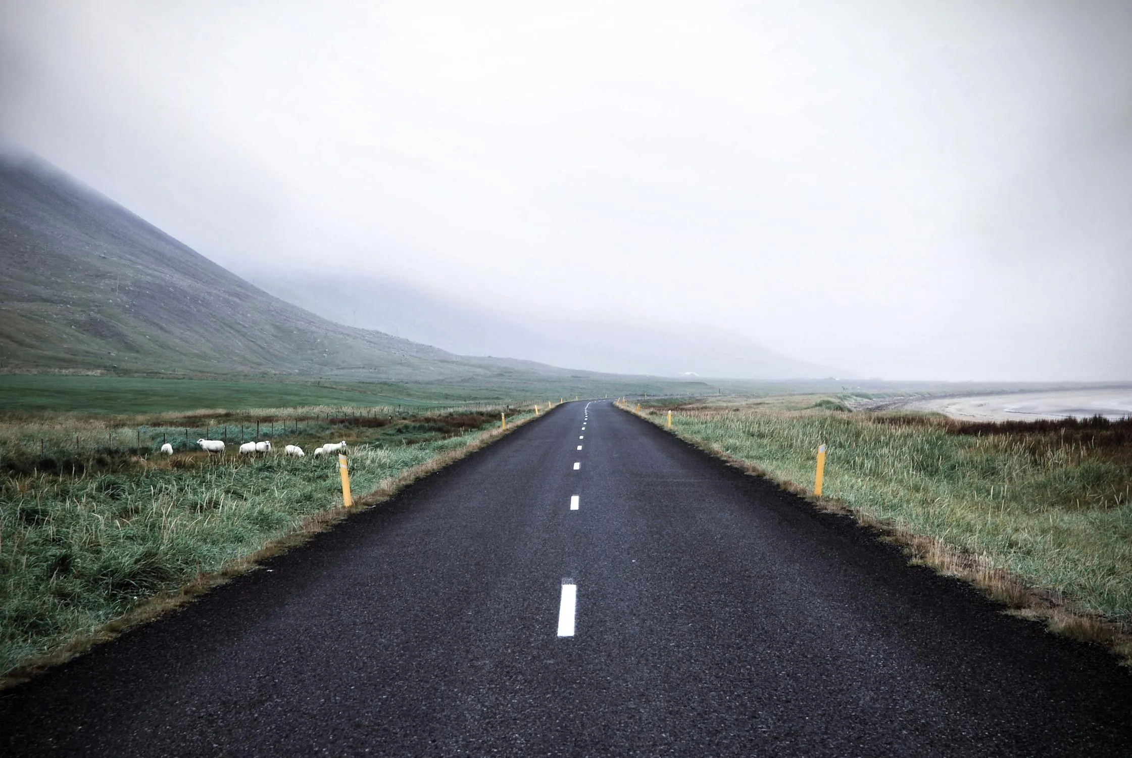 Road Cuts Through Mountain Under White Cloud Sky Image