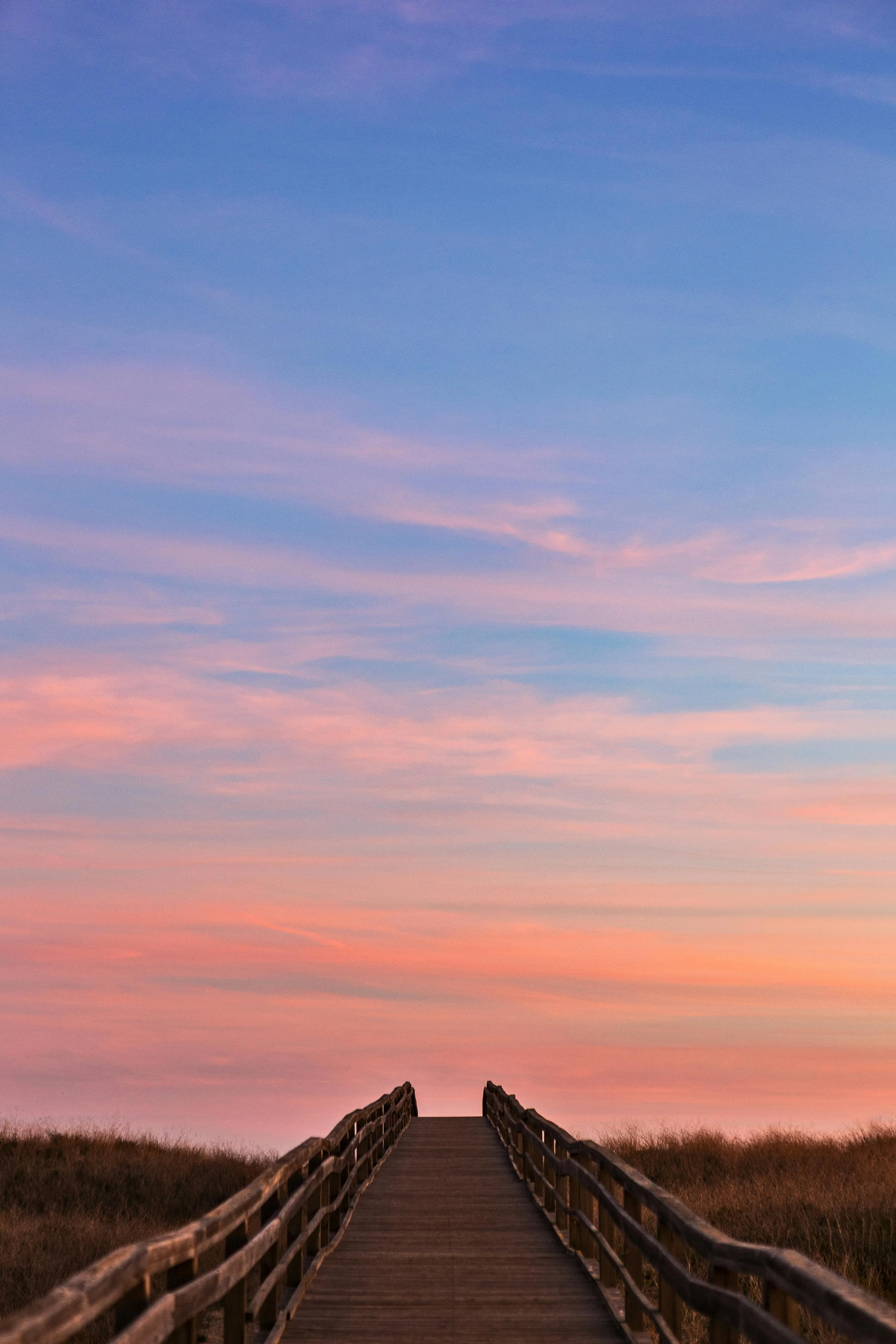 Road Leading To Horizon Under a Soft Sunset Cloud Sky