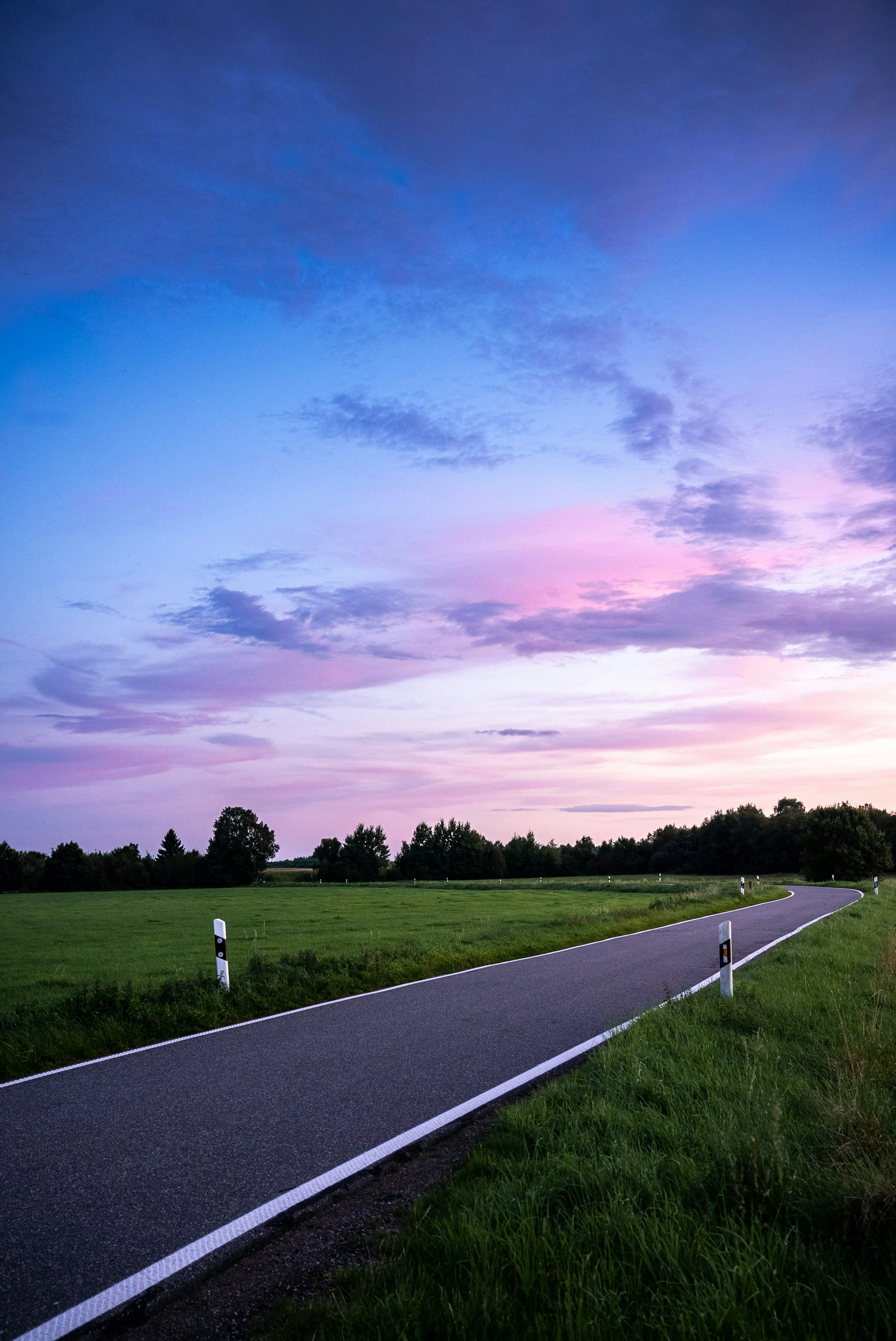 Road Stretching Into Horizon Under Purple Sunset Sky