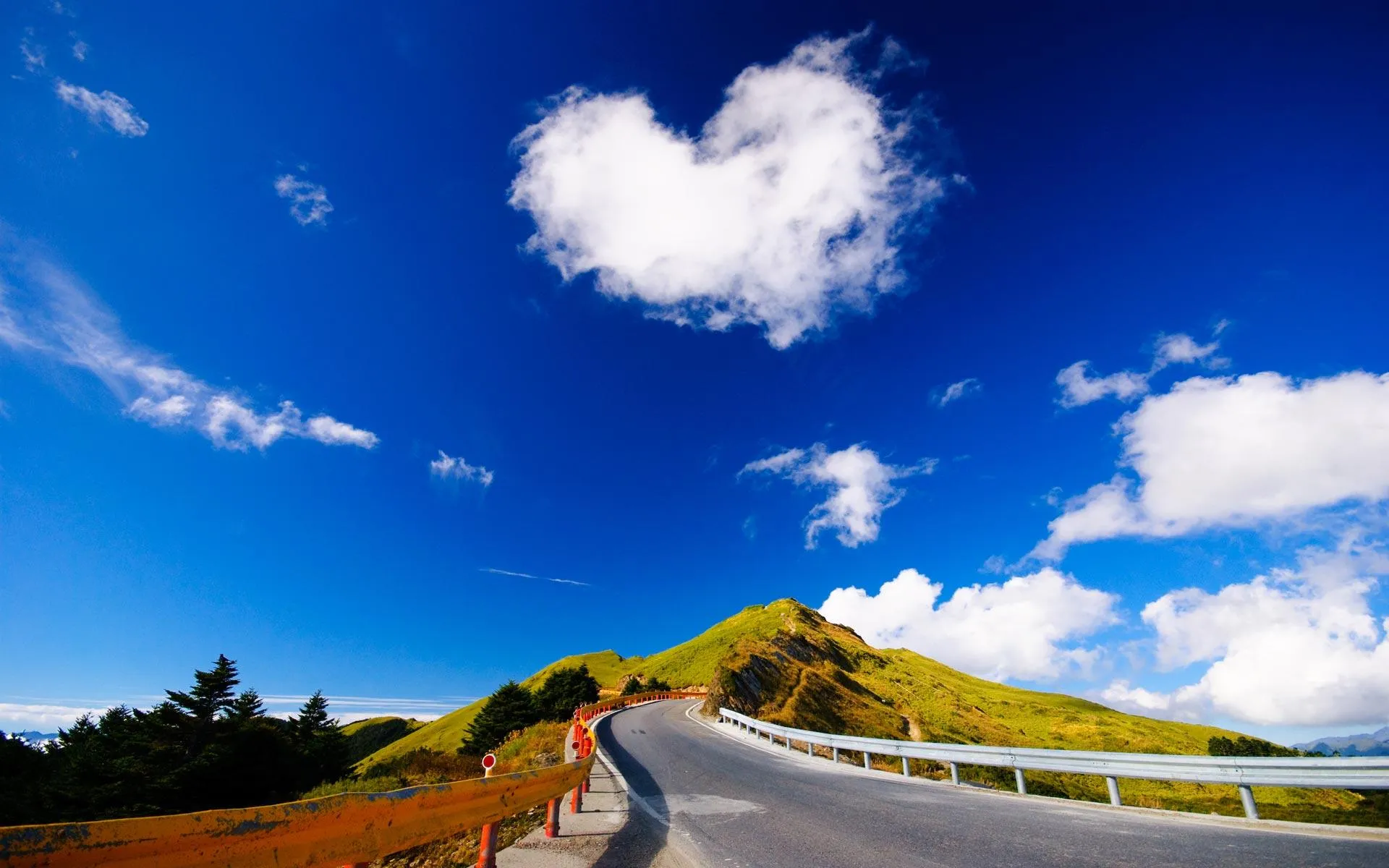 Road Winding Through Forest Beneath Heart Shaped Cloud