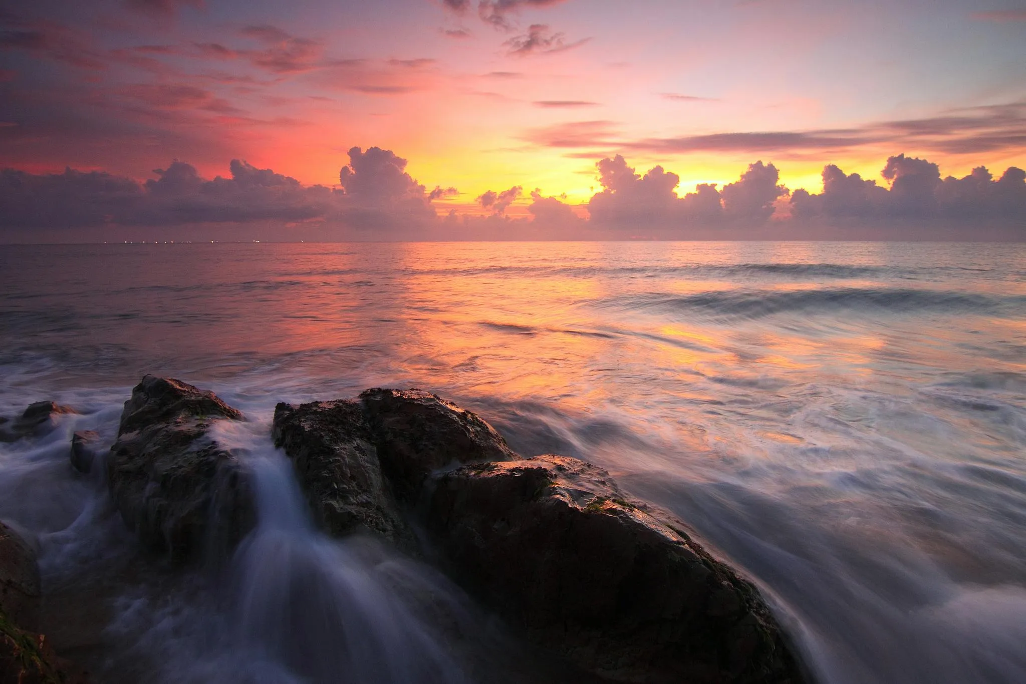 Rocky Coastline Under a Dramatic Pink and Purple Sunset