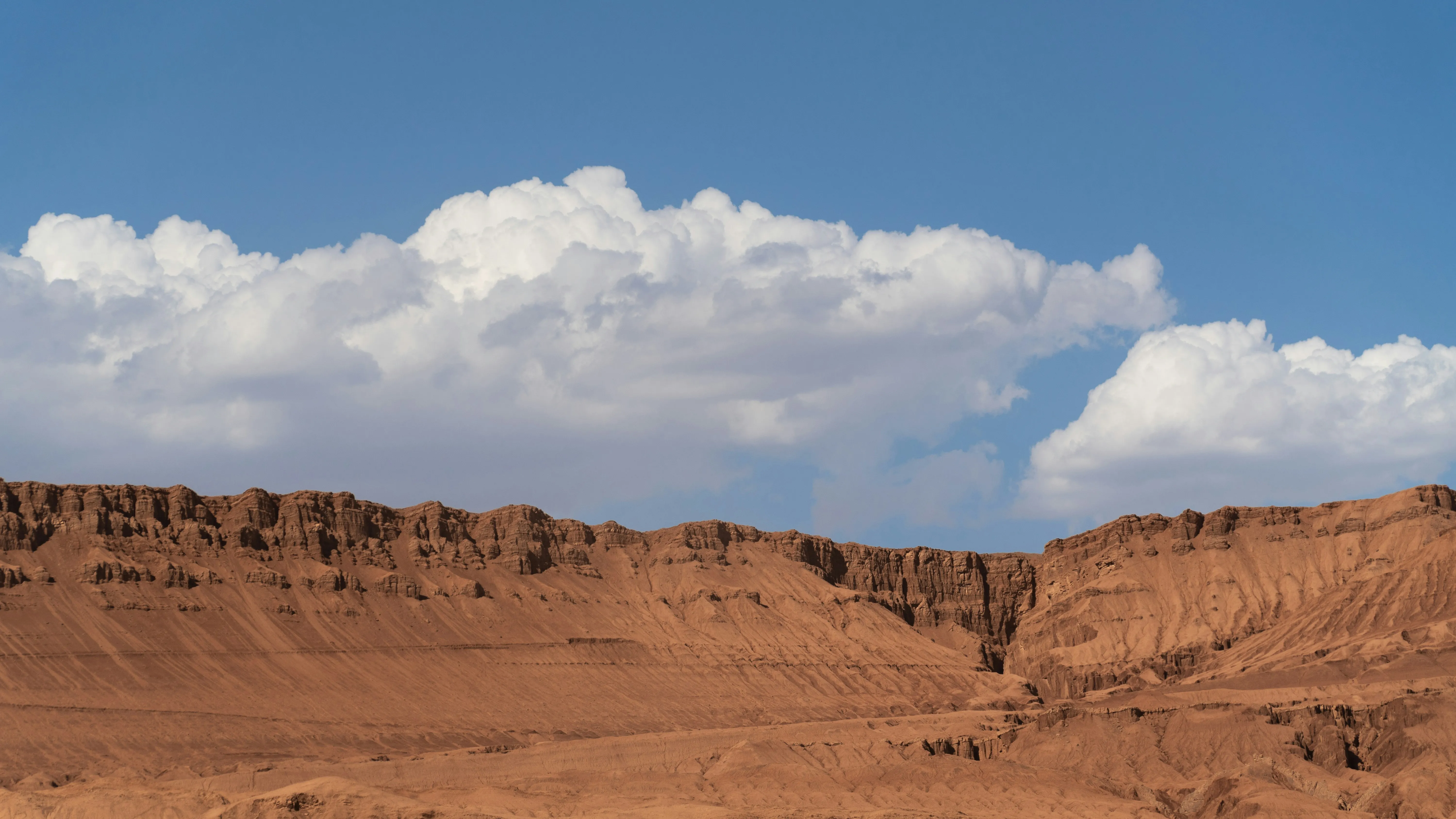 Rocky Desert Landscape Under Bright Blue Sky and Clouds