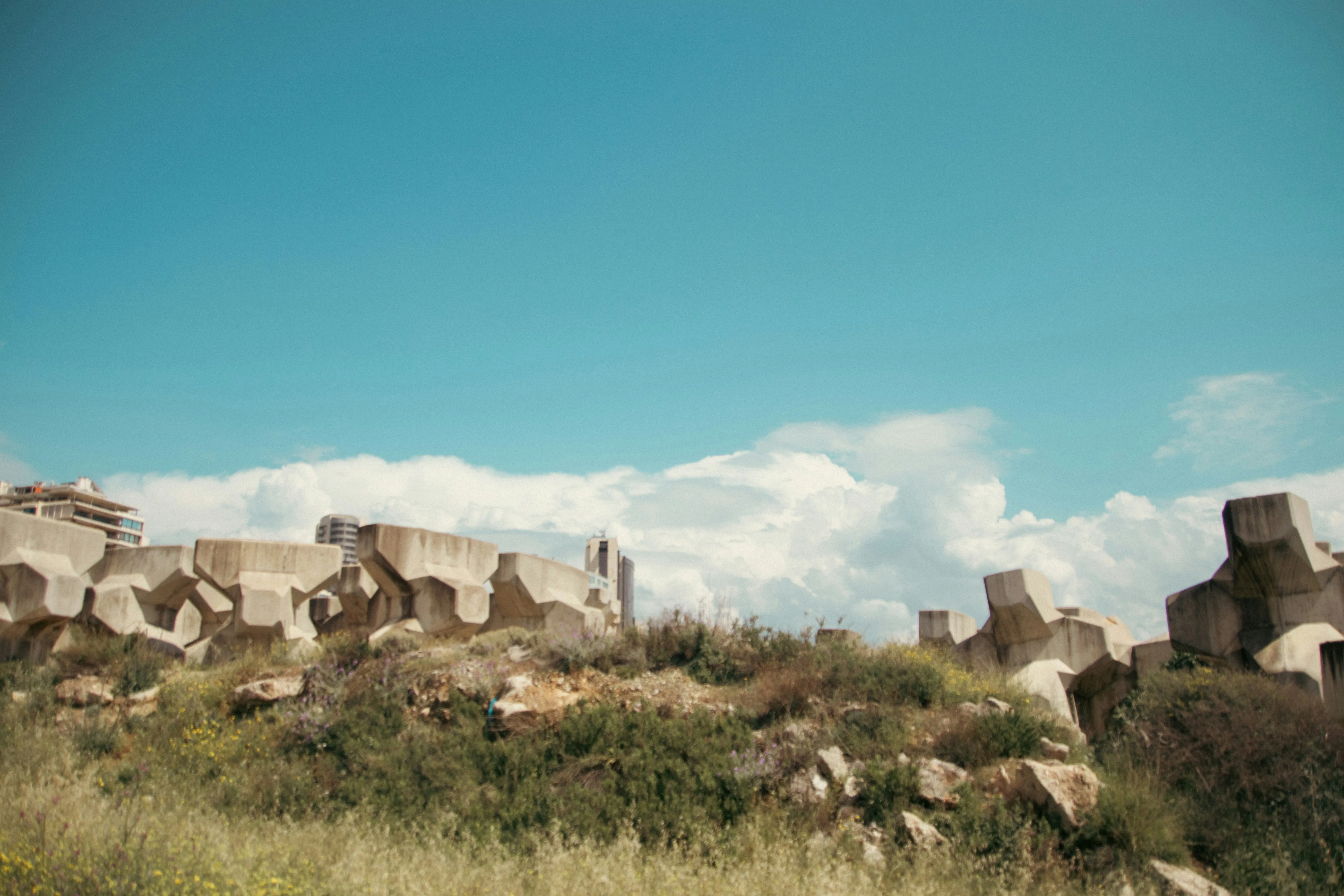 Rocky Landscape Under Blue Sky with Scattered White Clouds