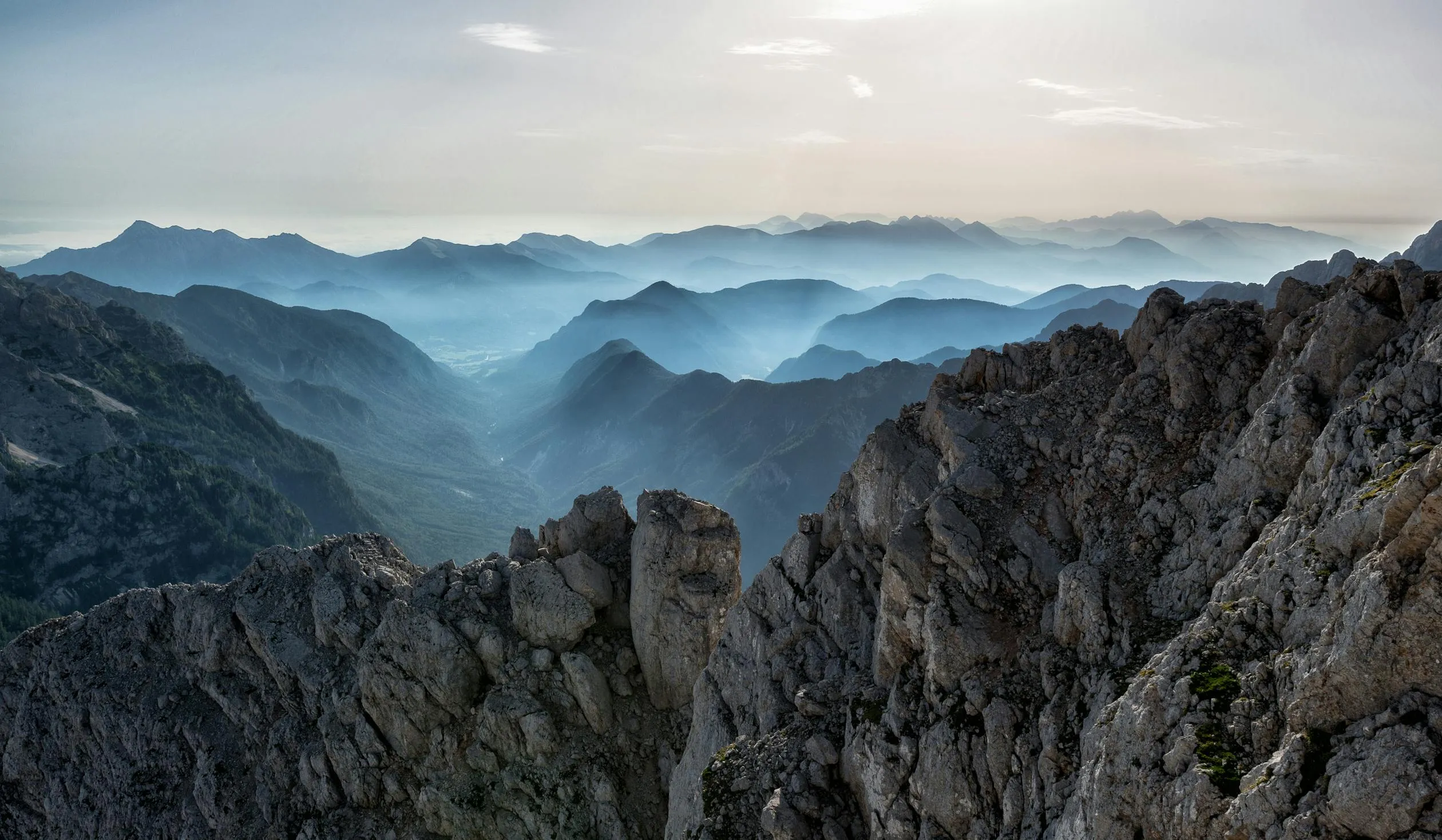 Rocky Mountain Range with Clear Blue Sky and Soft Clouds