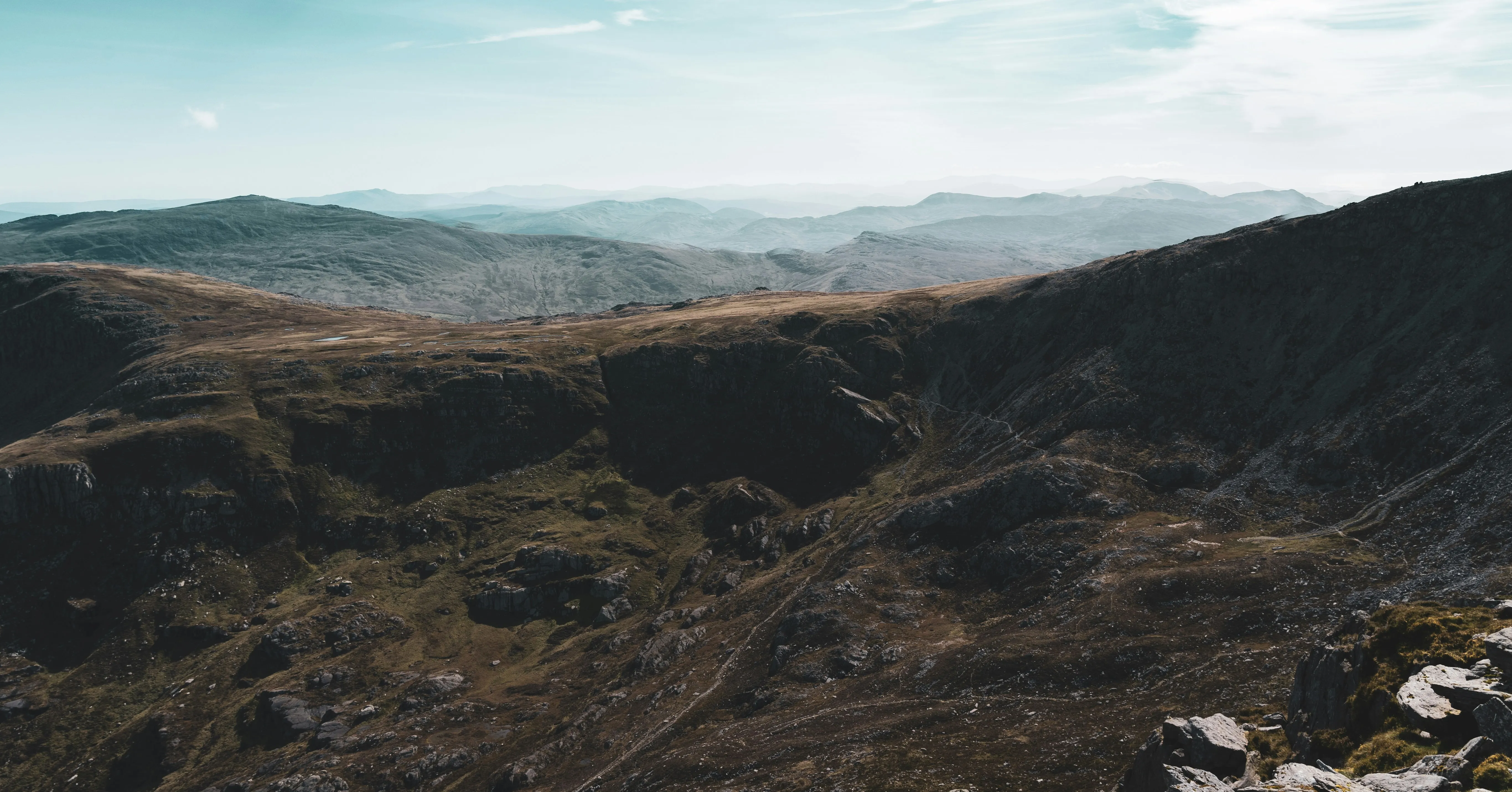 Rocky Mountain Terrain Under a Cloudy Blue Sky on a Clear Day