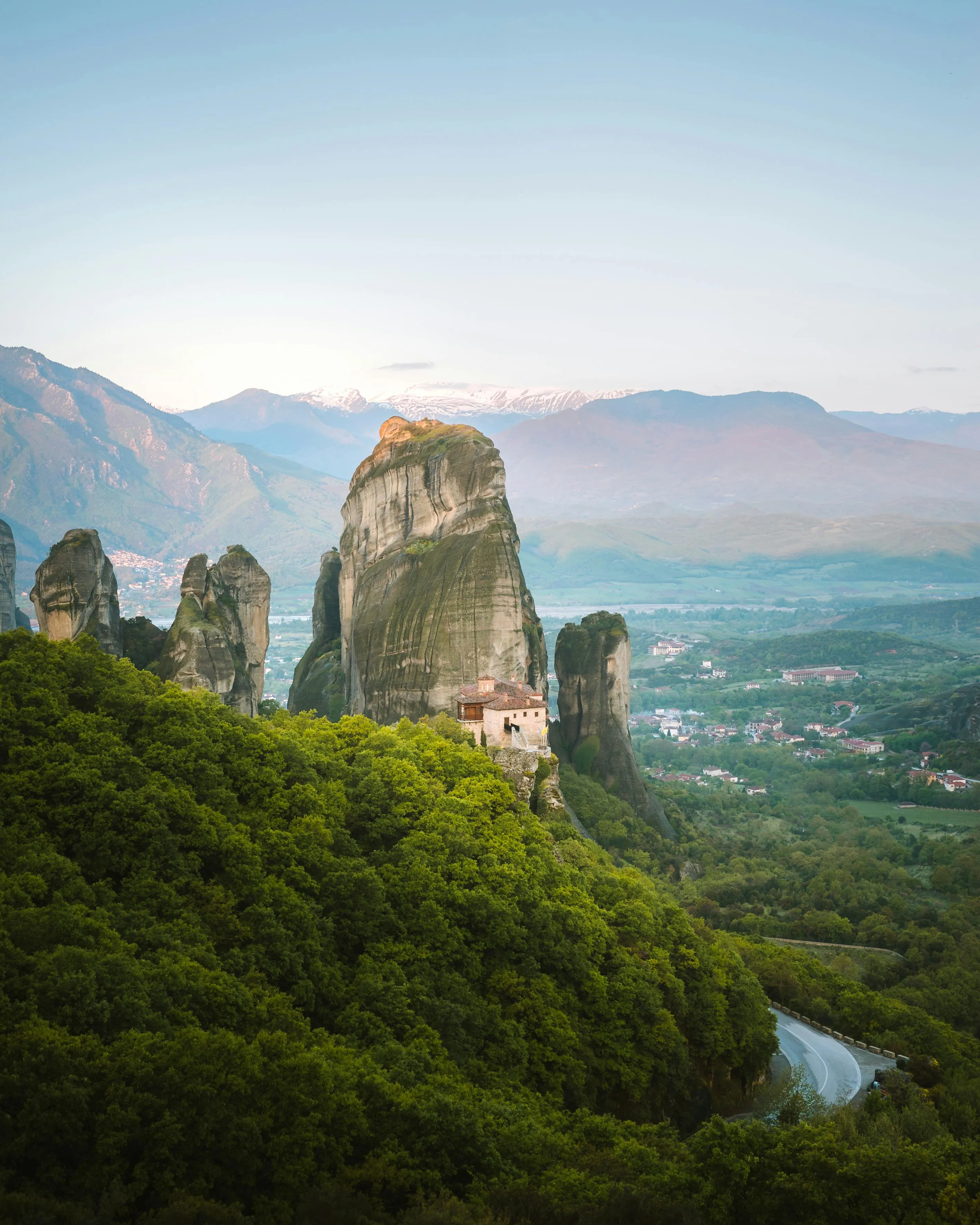 Rocky Peak Above a Forested Valley Under a Blue Sky View
